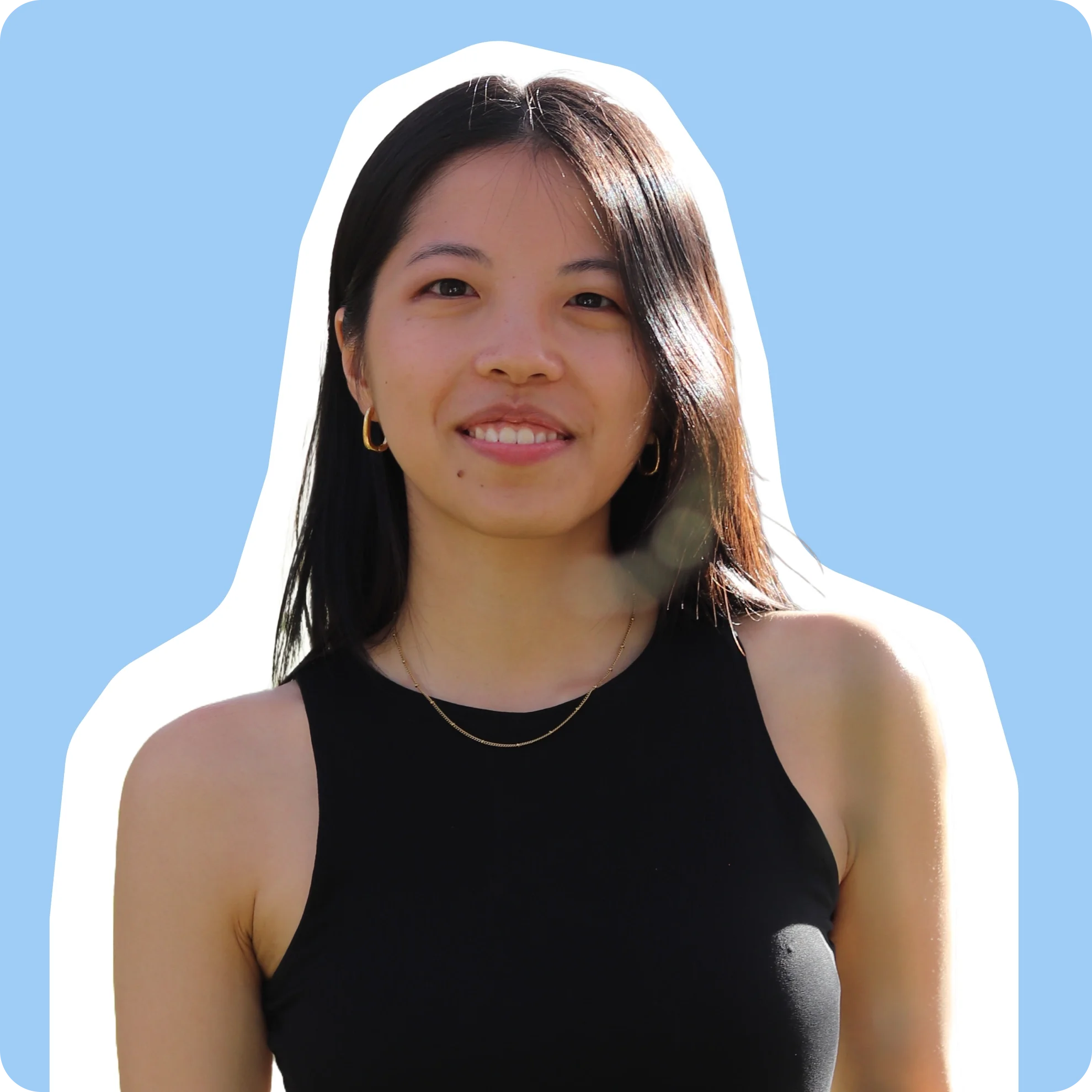 Product Designer with medium-length dark hair, wearing a black sleeveless top, and gold jewelry, smiling, portrait against a bright light blue background.