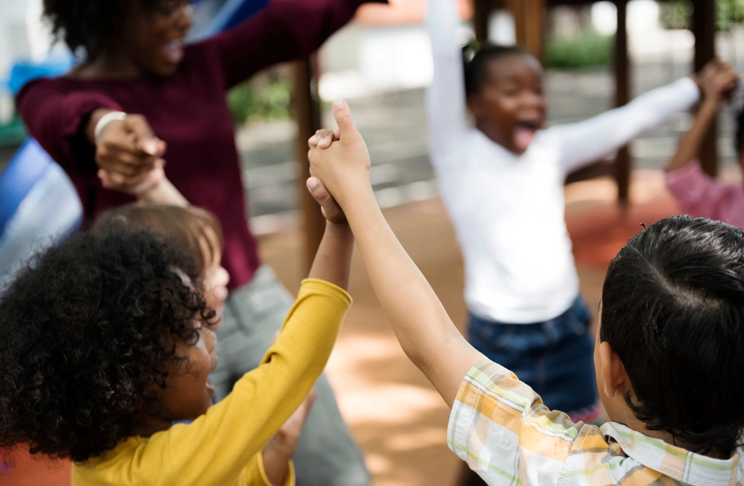 Image library for Stanford FIND: Children and adults holding hands and playing together outdoors.
