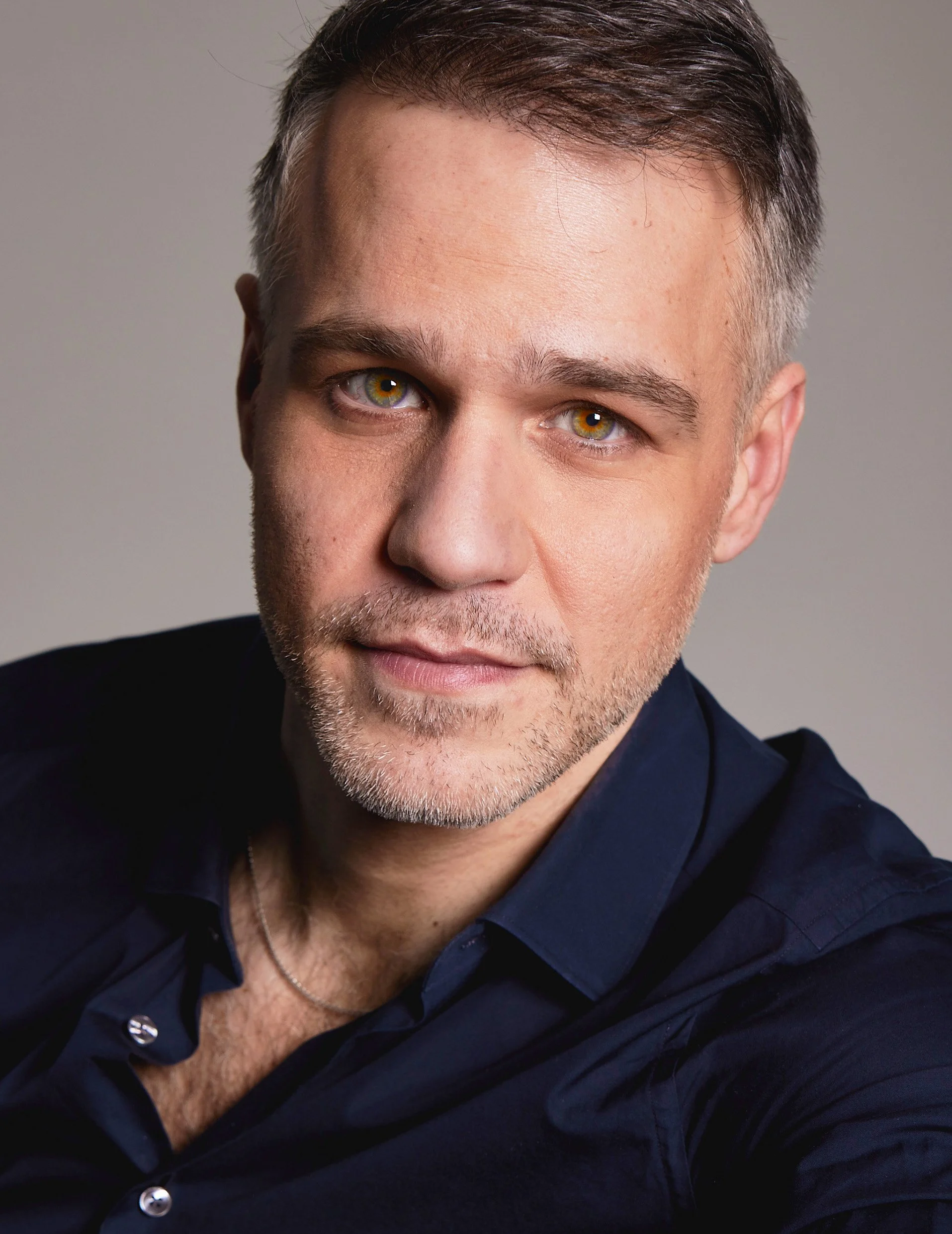 American-Greek-EU actor Taso Mikroulis Sag/aea actor in a blue shirt, hazel eyes, grey mixed brunette 40s male