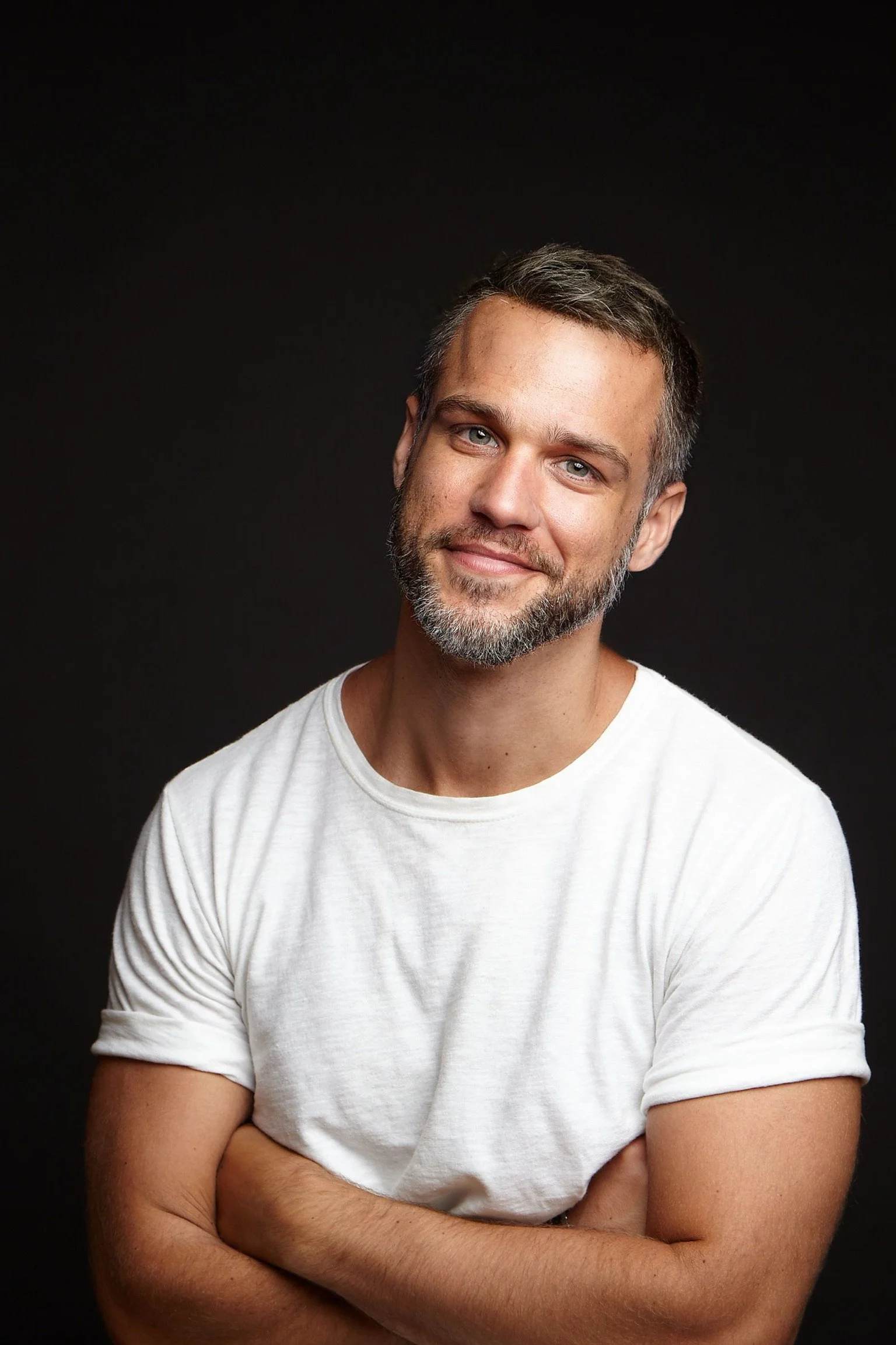 American-Greek-EU actor Taso Mikroulis Sag/aea actor in a white T-shirt, smiling, grey mixed brunette 40s male