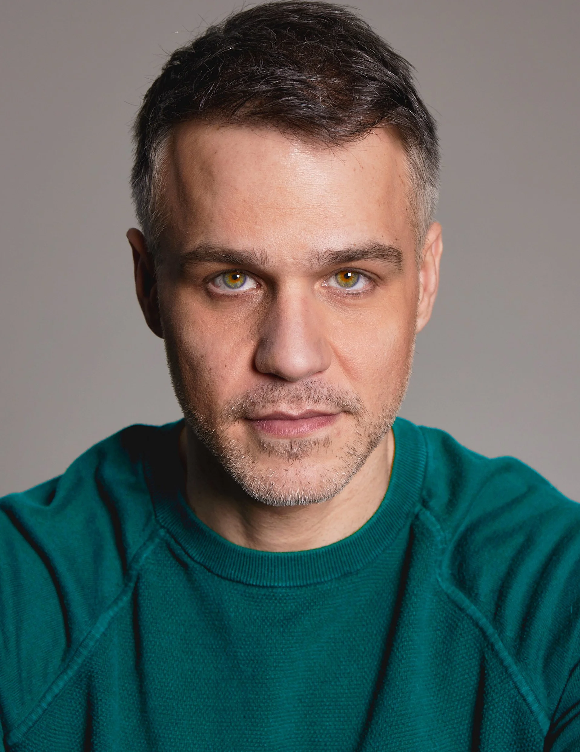 American-Greek-EU actor Taso Mikroulis Sag/aea actor green sweater, hazel eyes, velvet coat, blue eyes, grey mixed brunette 40s male