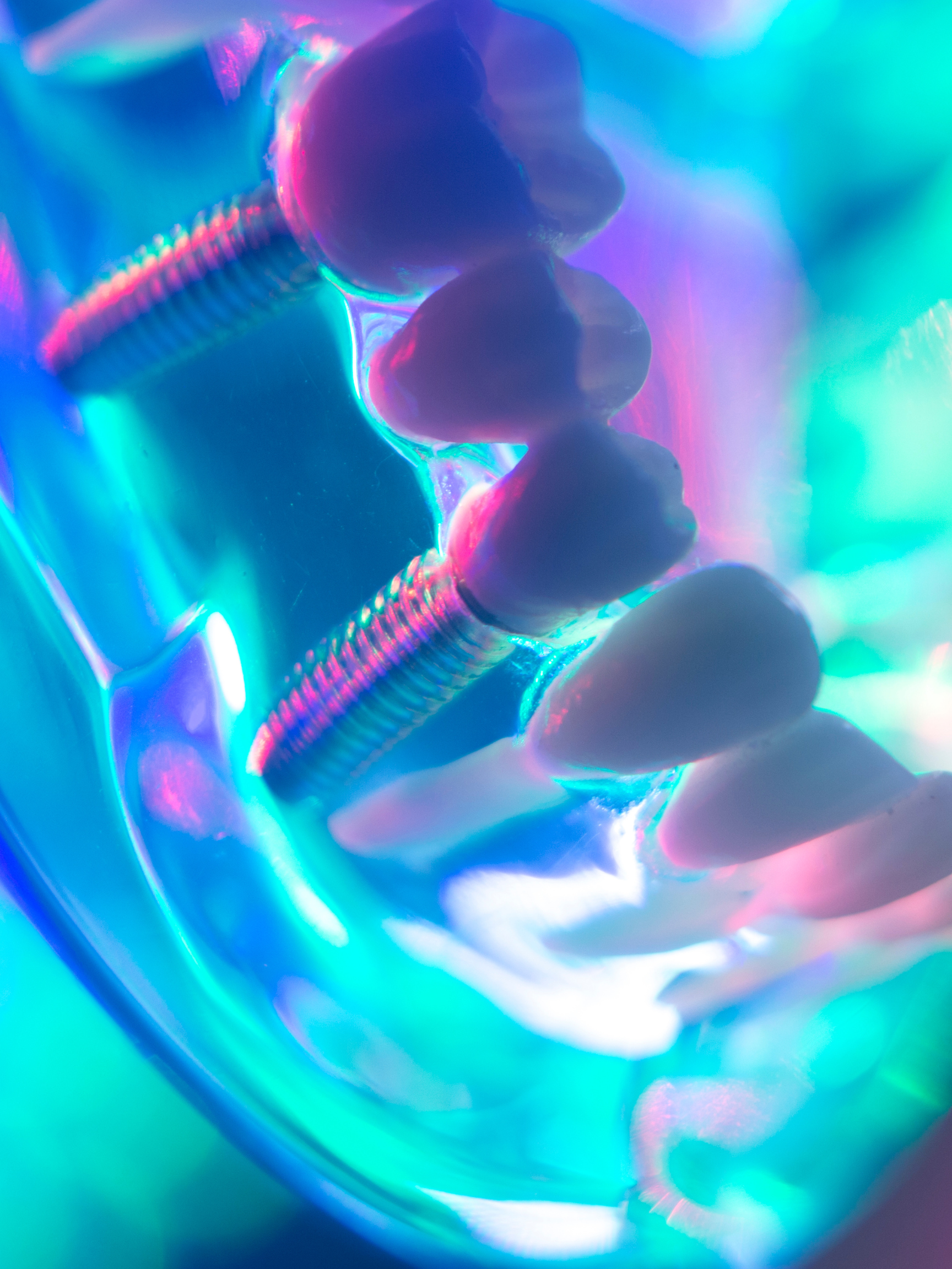 Un arreglo de tornillos en una estructura con luces de colores neón y efectos visuales vibrantes.