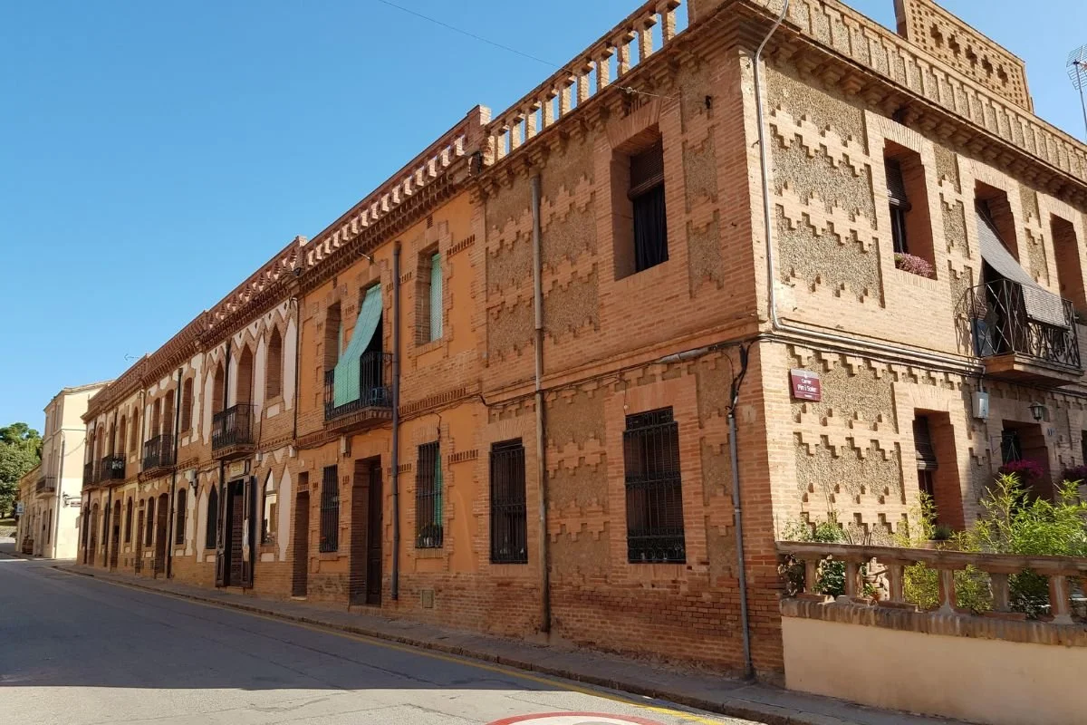 Arbejderboliger i Colònia Güell med murstensfacader og modernistiske detaljer.jpg