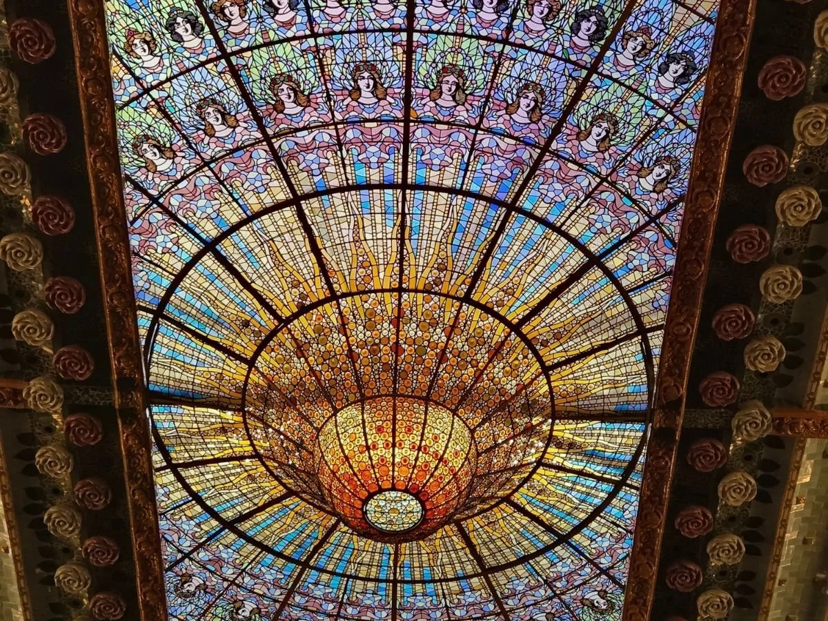 Glasmosaikken eller lucernariumet i blå, gule, lille og grønne farver lader lyset skinne ned i koncertsalen i Palau de la Música Catalana