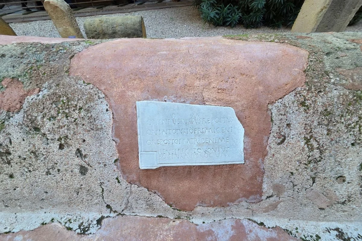 Nærbillede af en romersk grav med en lille marmorplade med latinsk inskription