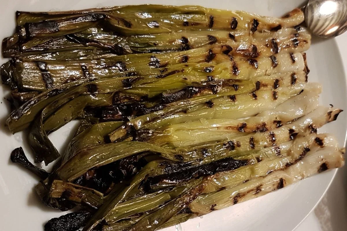 Grillede calçots serveret på et fad på en restaurant i Catalonien