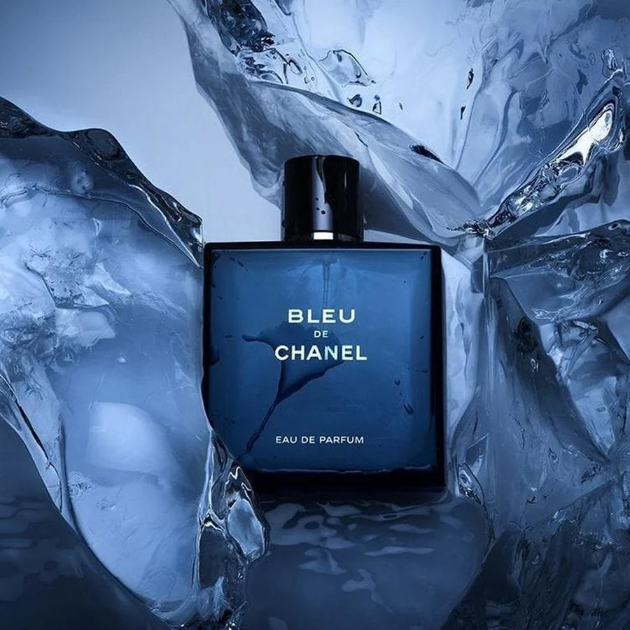 Blue Chanel perfume bottle surrounded by ice and crumpled foil.