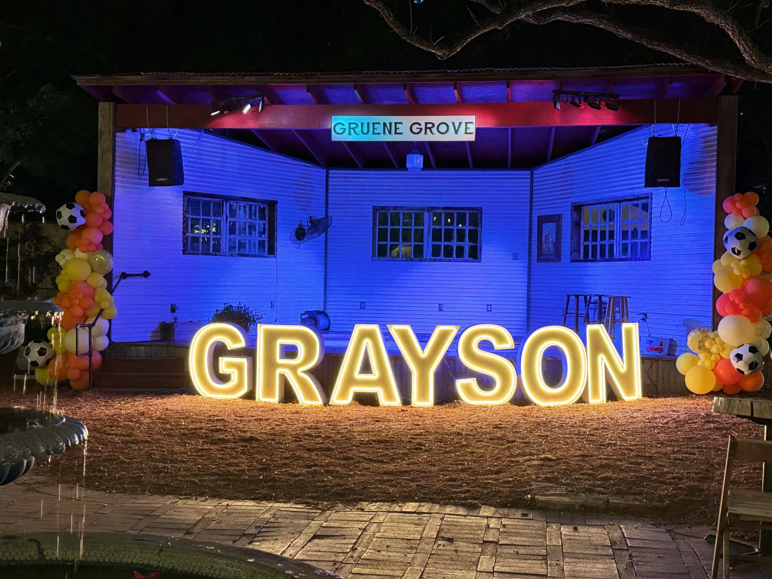 LED marquee letters spelling “GRAYSON” displayed at an outdoor event venue at night.