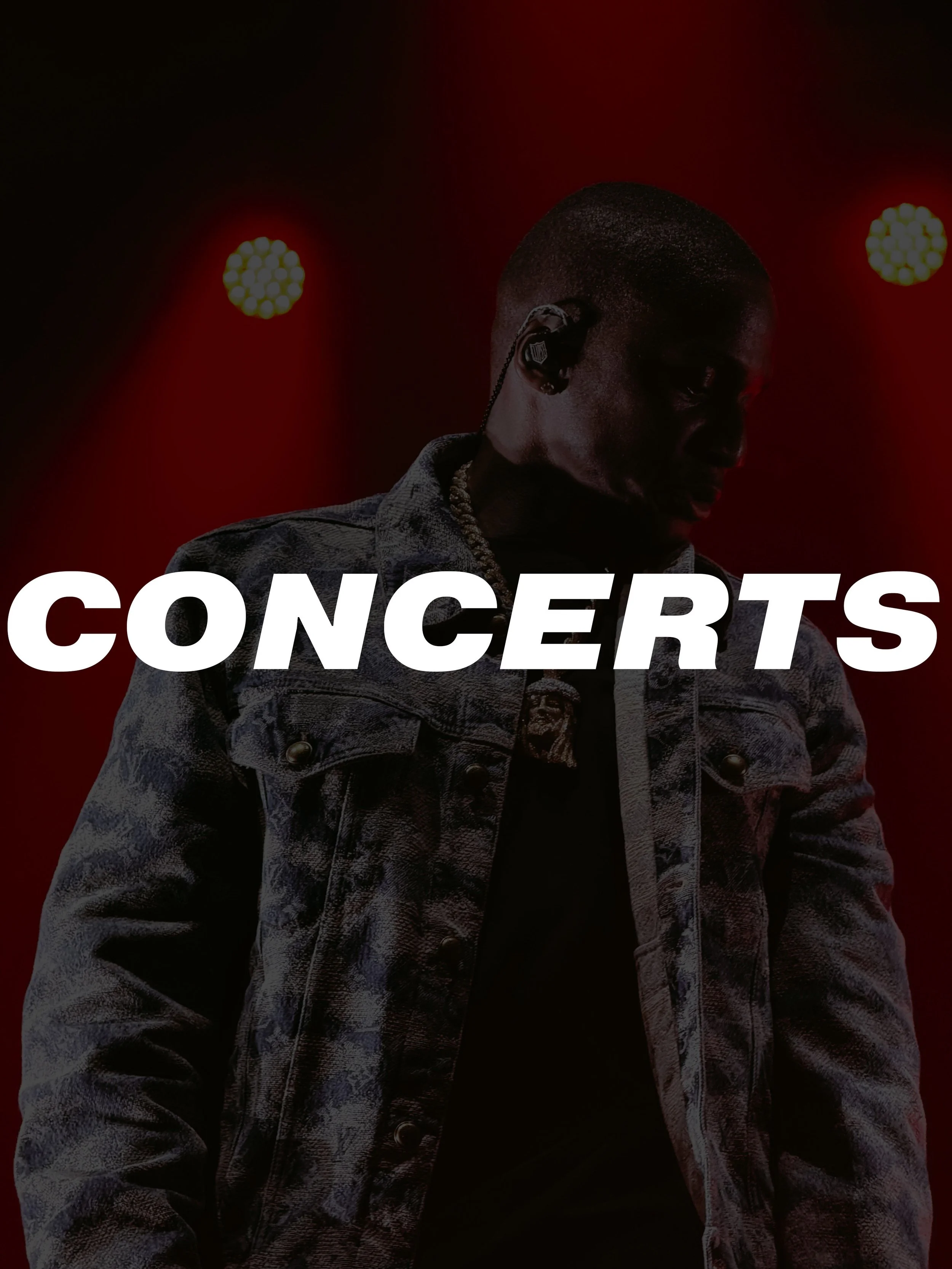 A male musician wearing a denim jacket, with an earpiece and jewelry, performing on stage with red lighting and the word 'CONCERTS' overlaid.
