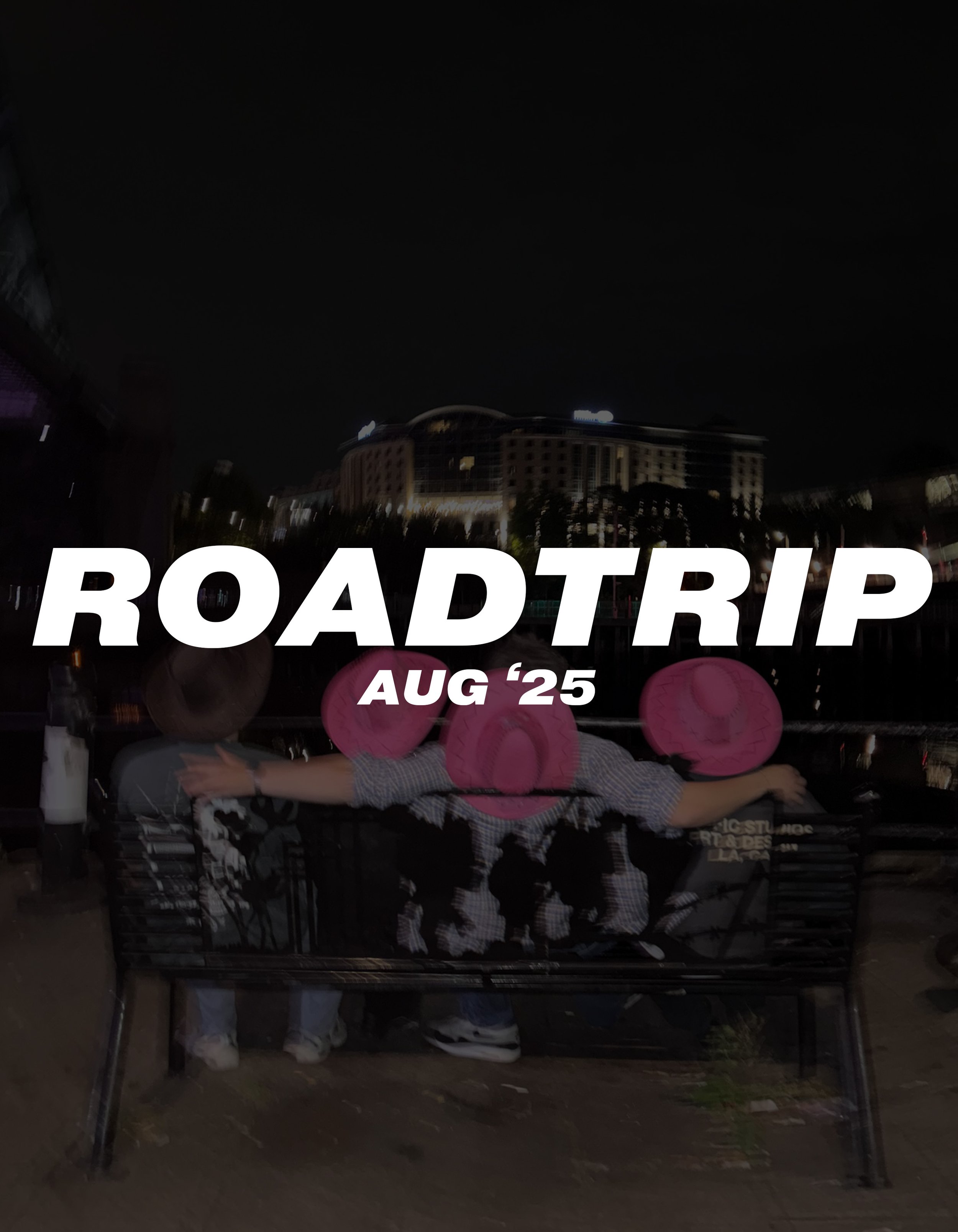 Nighttime photo of two children sitting on a bench, wearing pink hats, with a cityscape in the background. Overlaid text reads "ROADTRIP AUG '25."