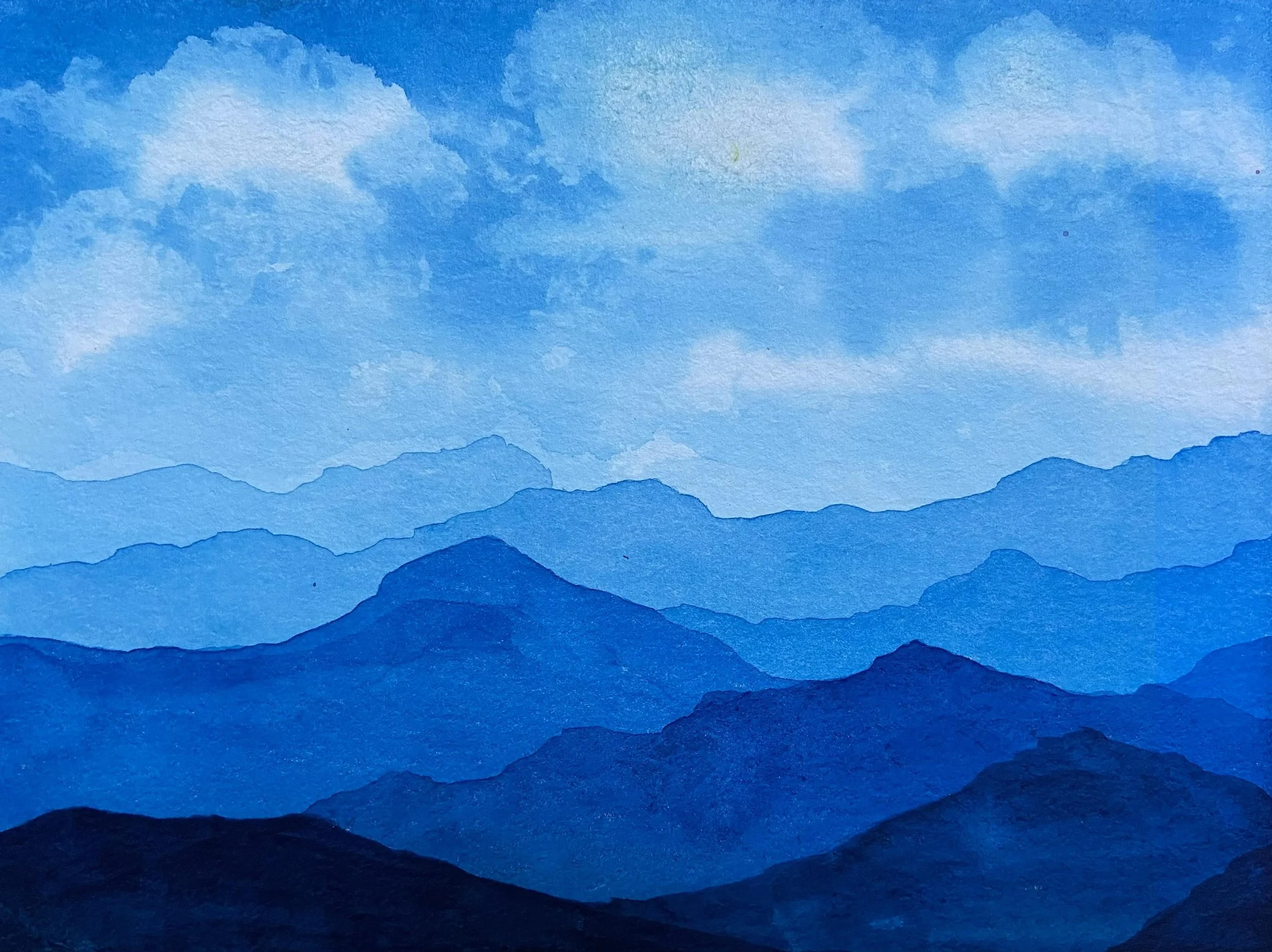 Watercolor painting of layered blue mountains under a partly cloudy sky.