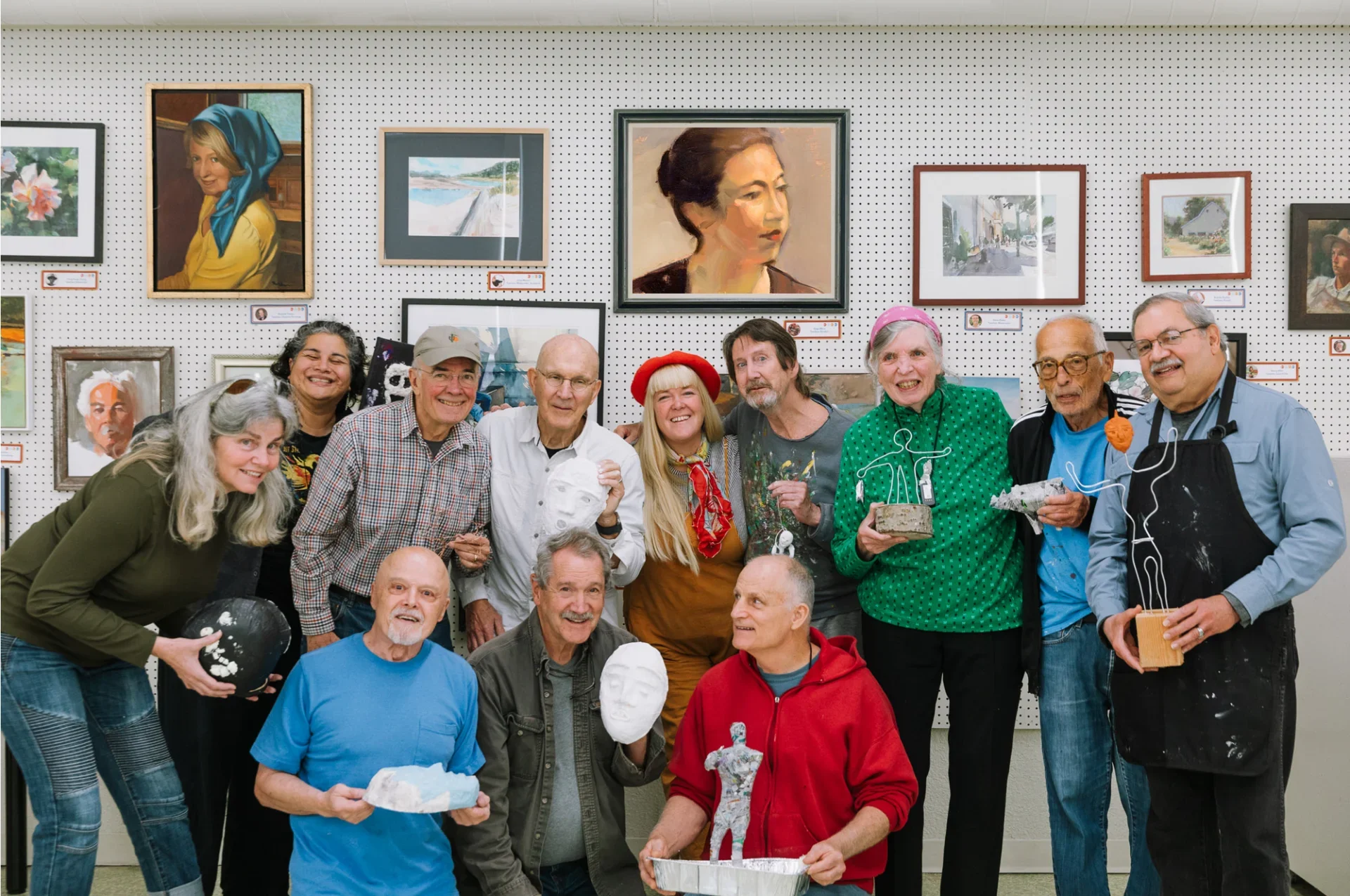 Group of people at an art gallery, showcasing sculptures and paintings.