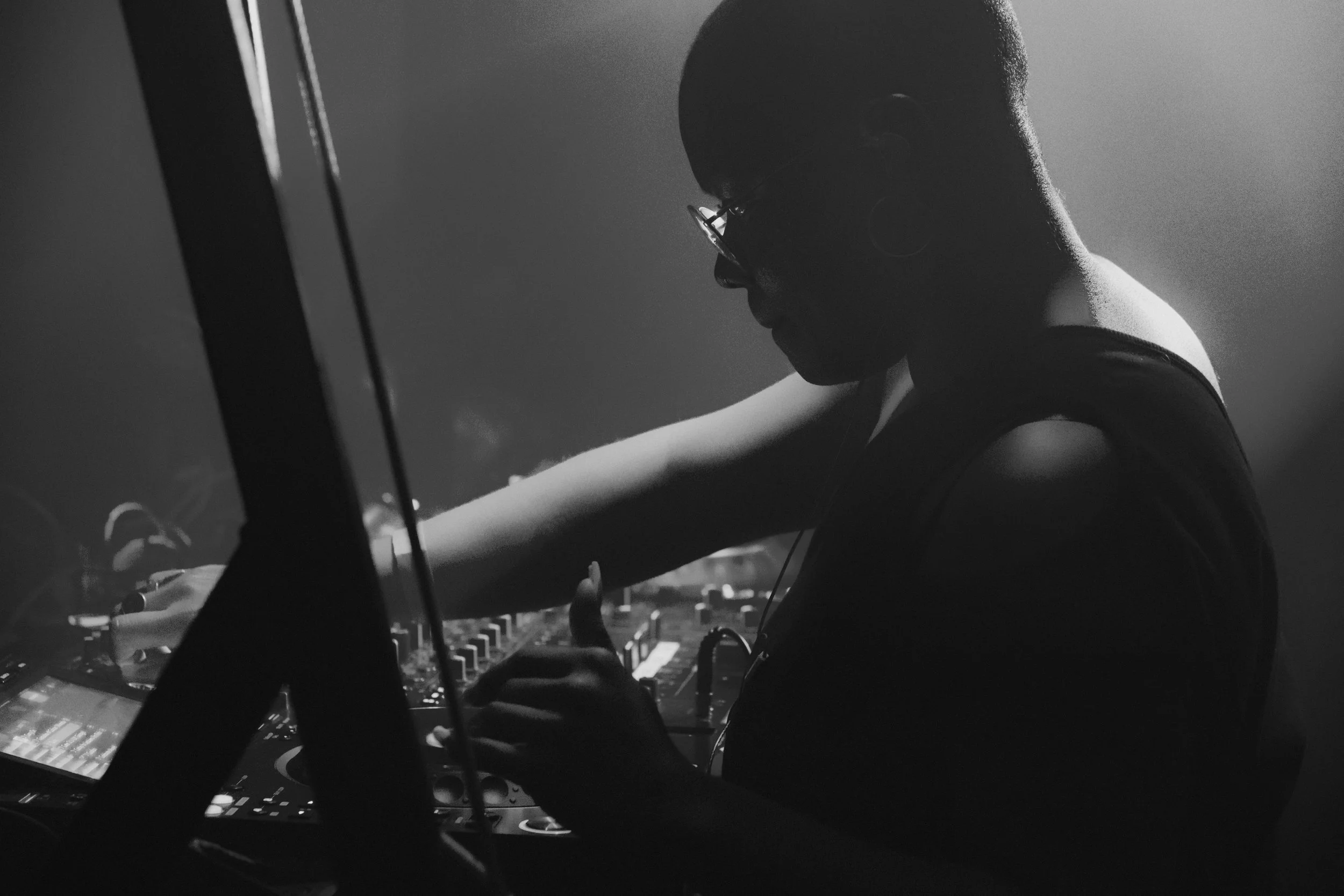 DJ with glasses focusing on CDJ