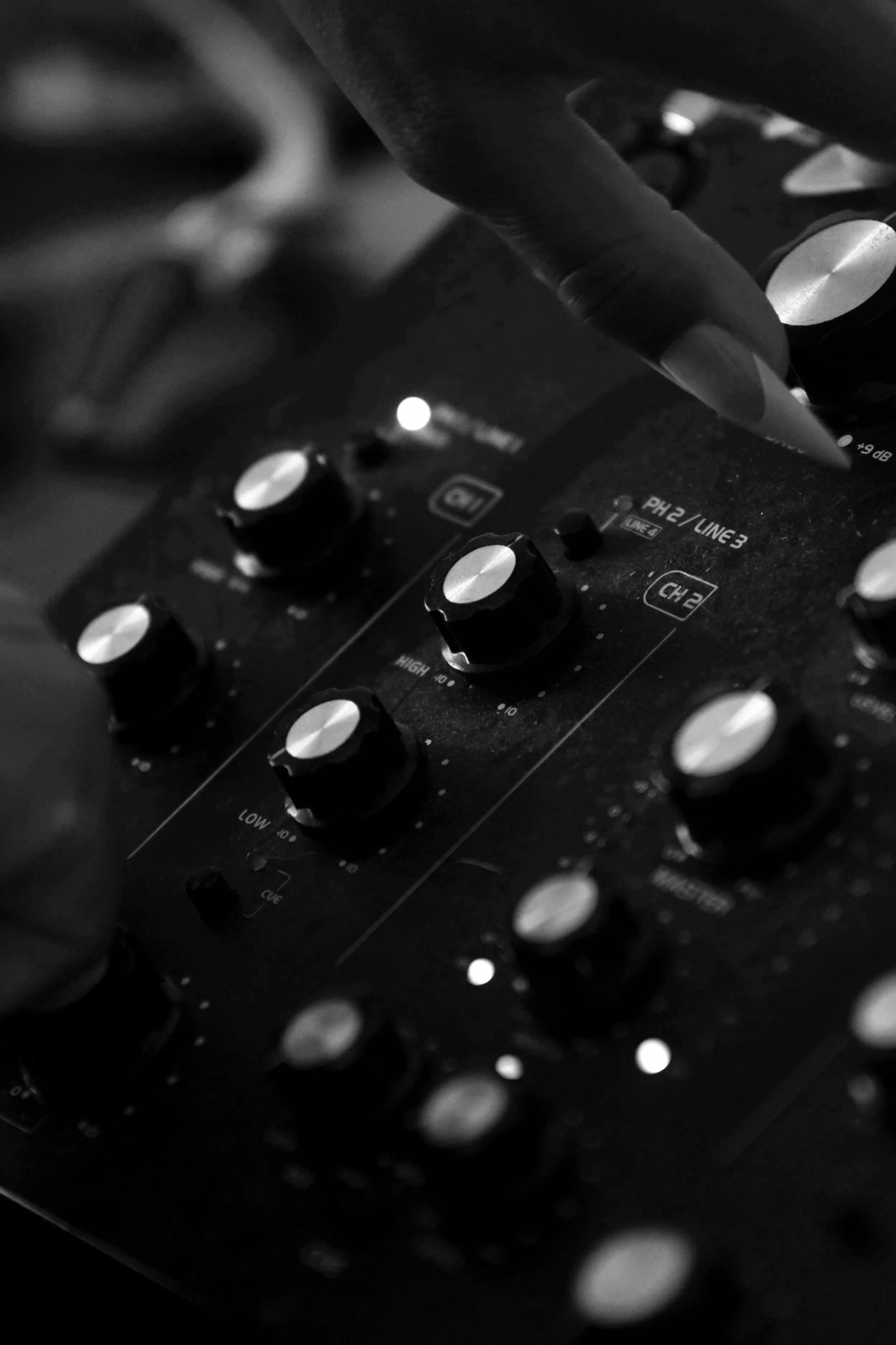 DJ with long nails turns knob on omnitronic rotary mixer