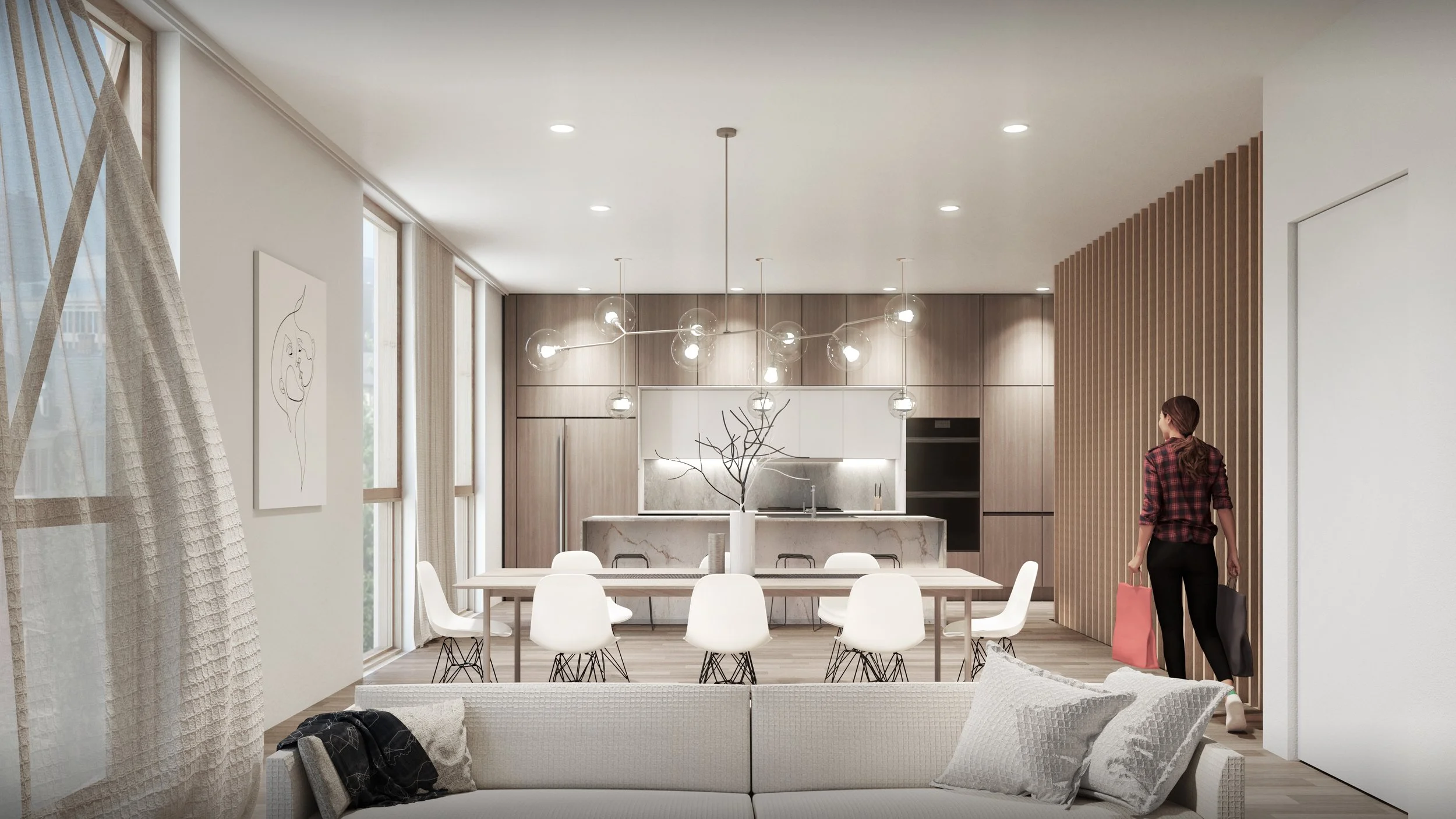 Modern open-plan kitchen and dining area with wooden cabinets, marble island, and a dining table with white chairs, with a woman walking in. Large windows with sheer curtains allow natural light. Minimalist decor with artwork and a branch centerpiece on the table.