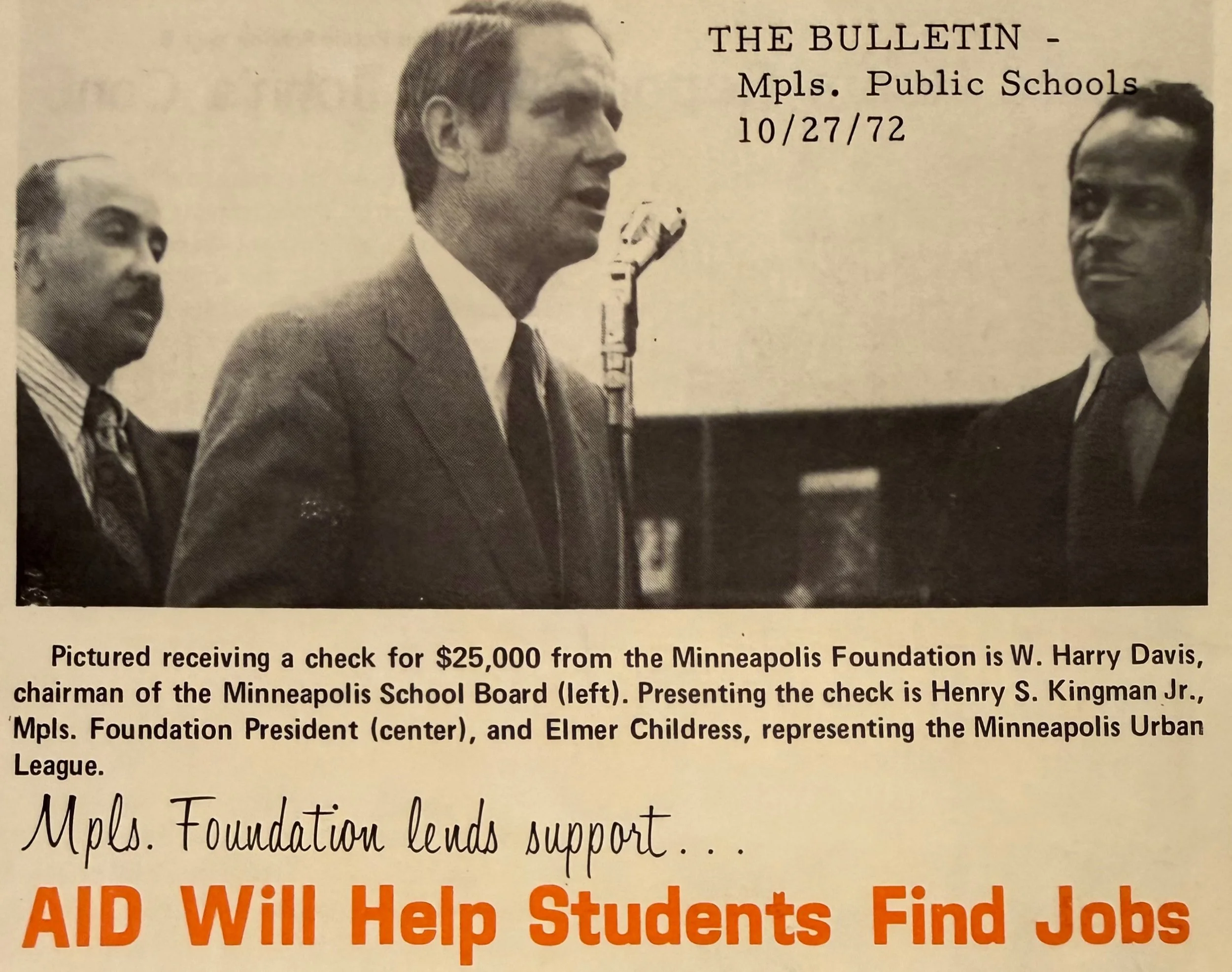 A black-and-white photograph showing three men in suits in a formal setting, with a microphone on a stand. The man in the center, Henry S. Kingman Jr., presents a check for $25,000 from the Minneapolis Foundation to the chairman of the Minneapolis School Board, W. Harry Davis, who is on the left. Elmer Childress, representing the Minneapolis Urban League, is on the right. The image is part of a bulletin from MPLS Public Schools dated October 27, 1972, with a caption and a headline "AID Will Help Students Find Jobs".