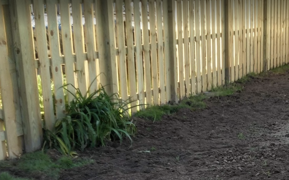 Fence with clean dirt around it after spring clean up in Cleveland