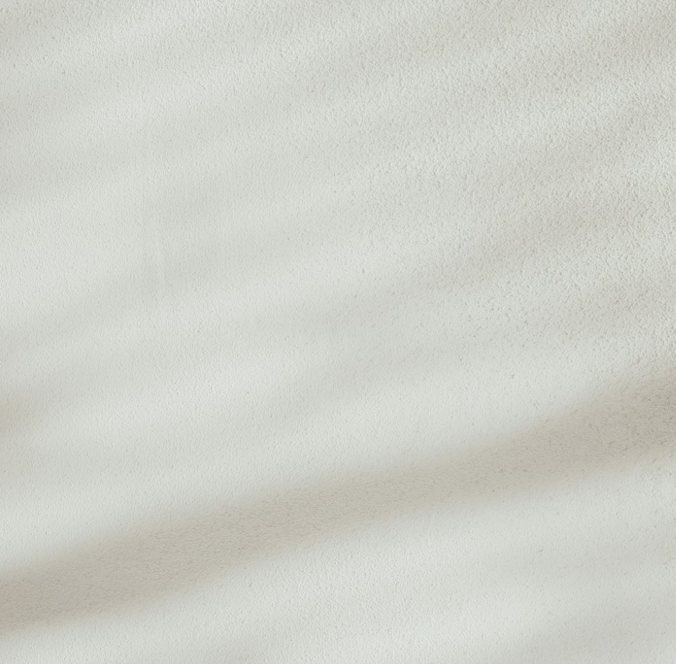 Close-up of a plain off-white textured wall with a faint shadow.