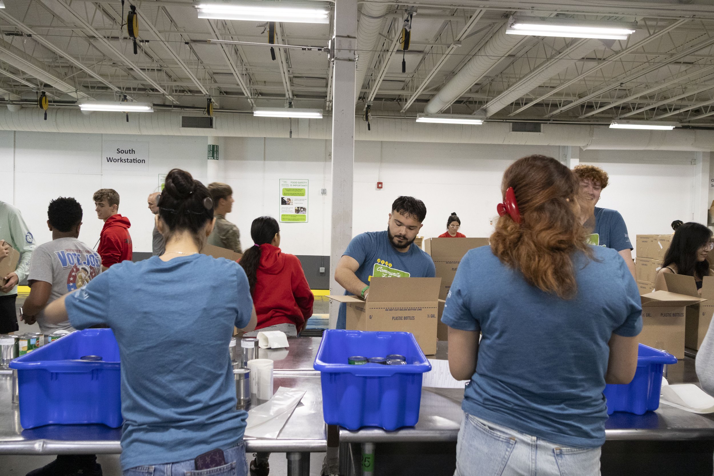 Community Fellows pack boxes of nonperishable food during a volunteer visit to the Regional Food Bank of Oklahoma.