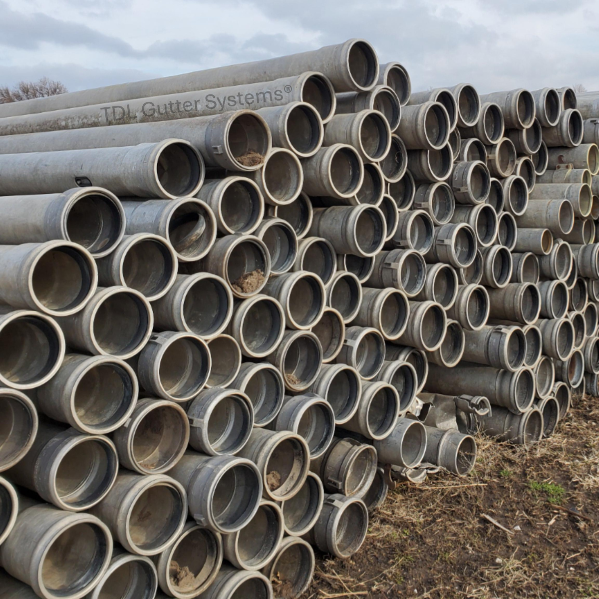 A large stack of aluminum irrigation pipe.