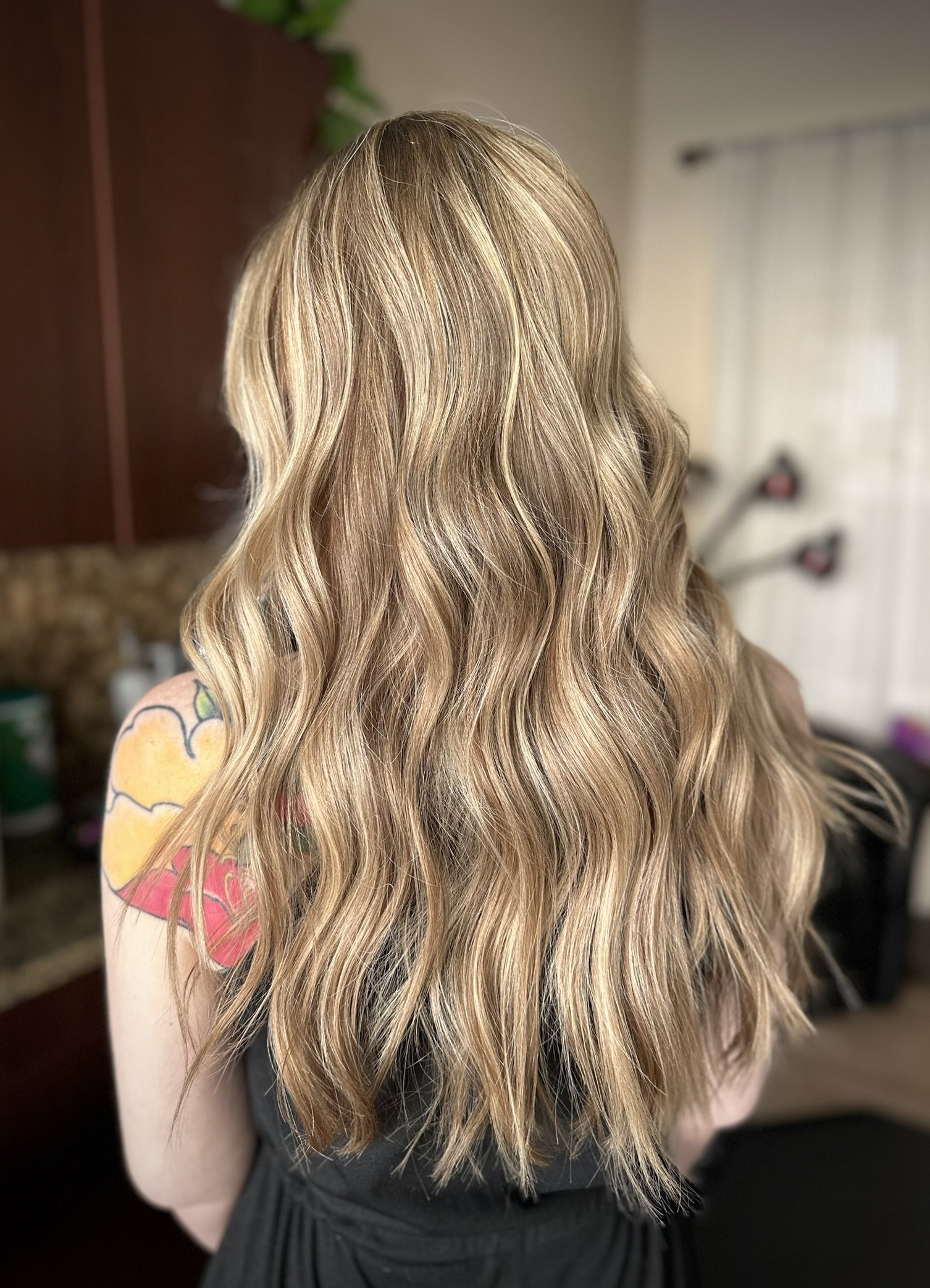 Dimensional lived-in blonde hair featuring soft balayage, bright face-framing highlights, and hints of strawberry blonde for a seamless, low-maintenance finish created by Leah Taylor Salon in St. Petersburg, Florida.