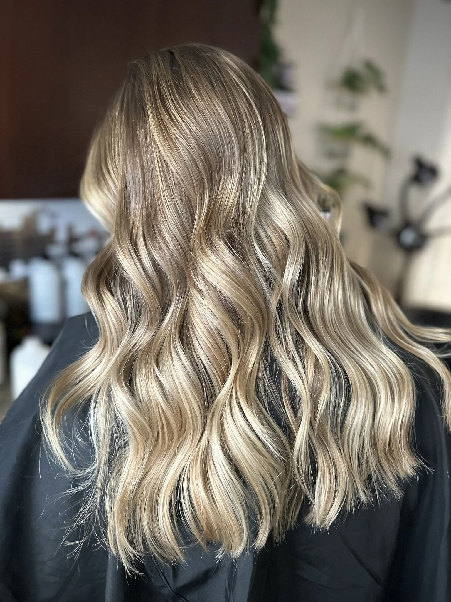 Dimensional lived-in blonde featuring beige blonde ribbons, a soft shadow root, and seamless low-maintenance grow-out created by Leah Taylor Salon in St. Petersburg, Florida.