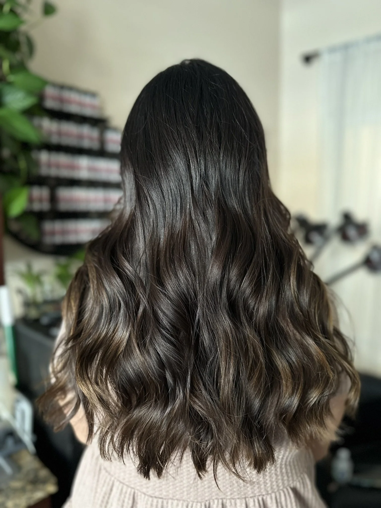 Rich dark brunette hair featuring espresso and chocolate brown tones styled with soft waves by Leah Taylor Salon in St. Petersburg, Florida.