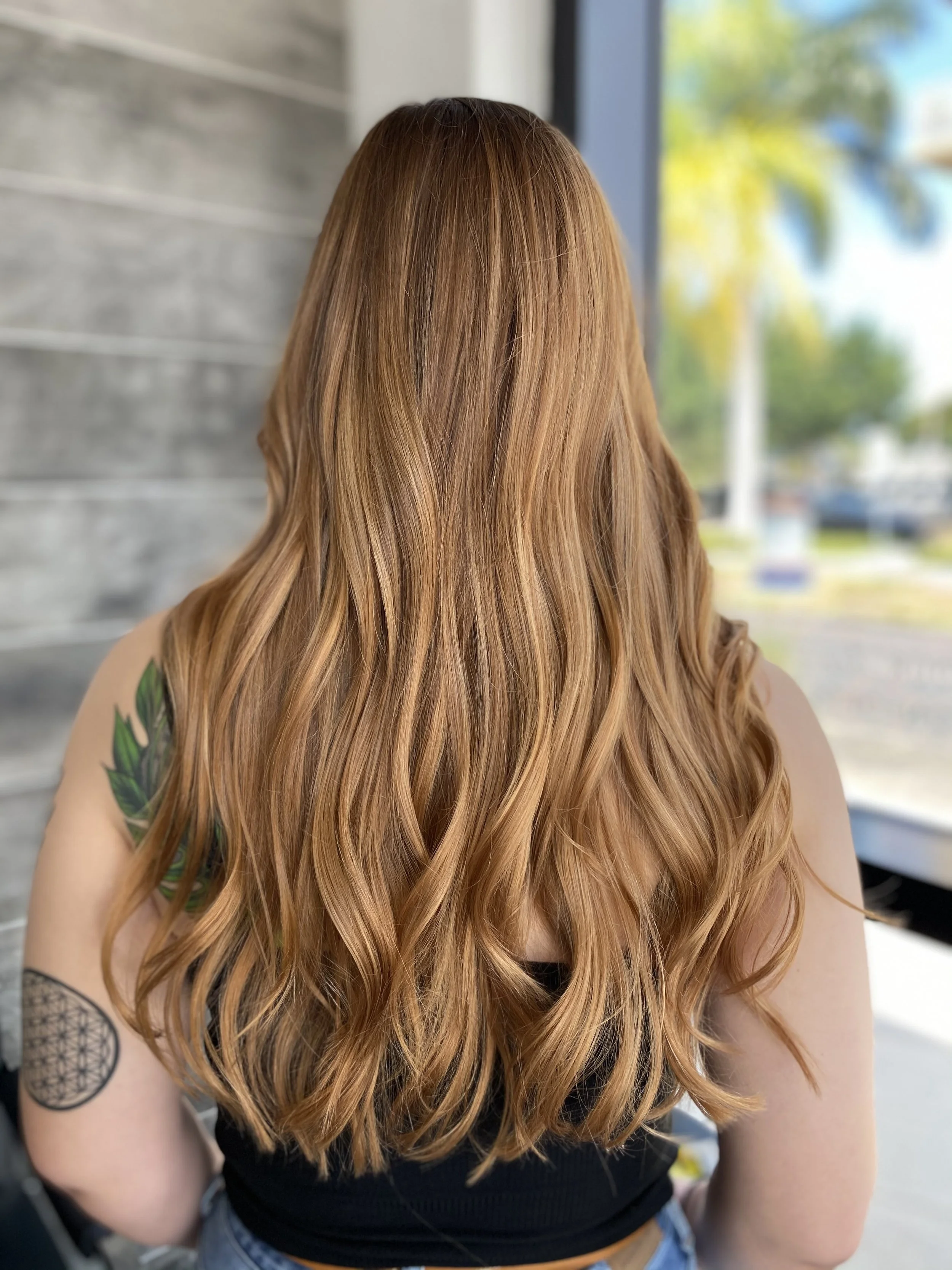 Dimensional copper hair color featuring soft strawberry blonde ribbons and warm golden tones created by Leah Taylor Salon in St. Petersburg, Florida.