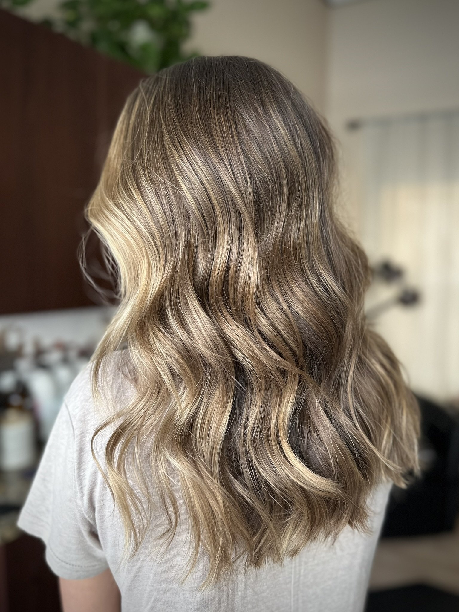 Dimensional bronde hair with soft blonde ribbons, lived-in depth, and beachy waves by Leah Taylor Salon in St. Petersburg, Florida.