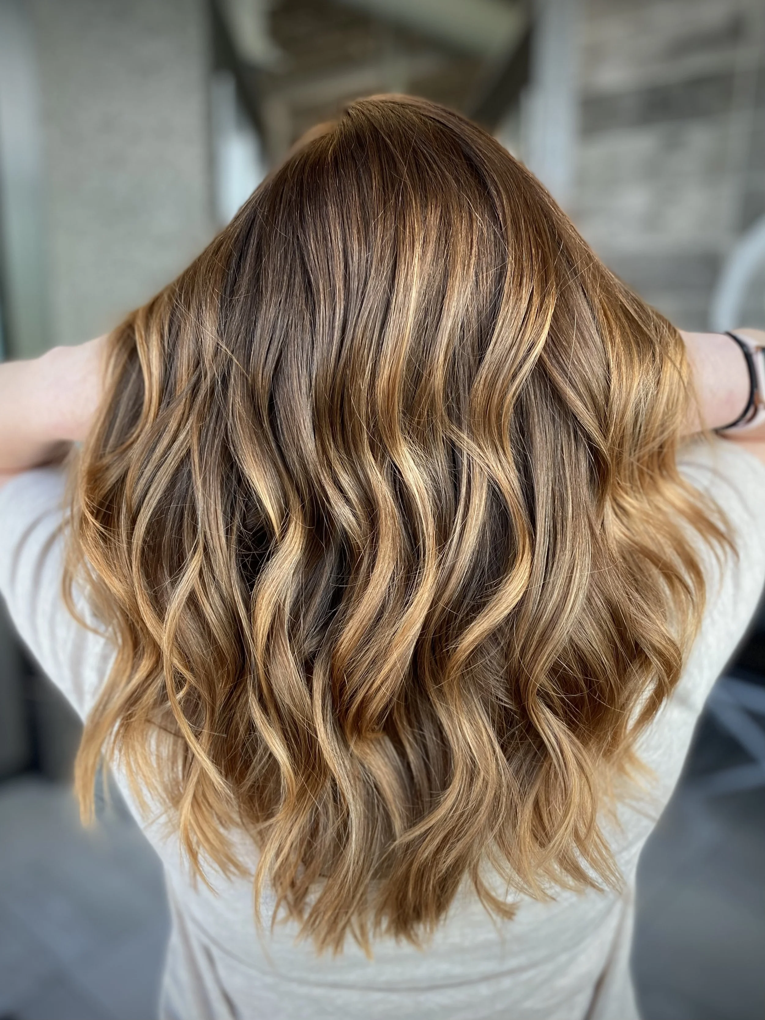 Warm bronde hair color featuring caramel balayage, golden ribbons, and dimensional brunette depth created by Leah Taylor Salon in St. Petersburg, Florida.