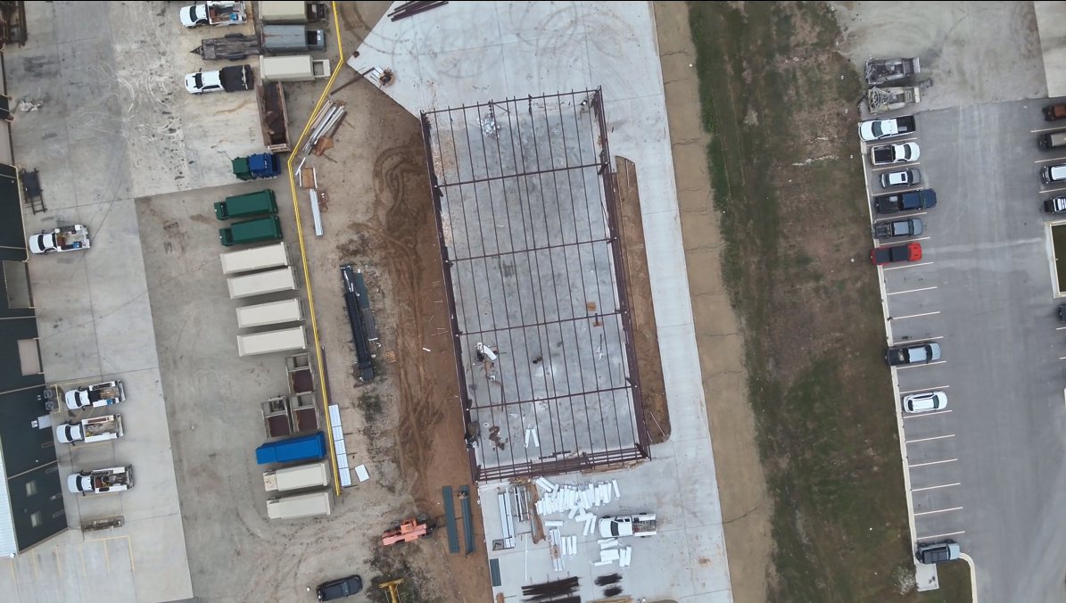 Aerial view of red iron erection and surrounding site conditions commercial project Bryan, TX.