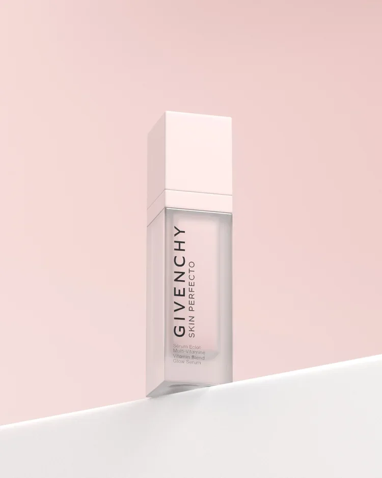 A bottle of Givenchy Skin in Perfecto glow serum against a pink background.
