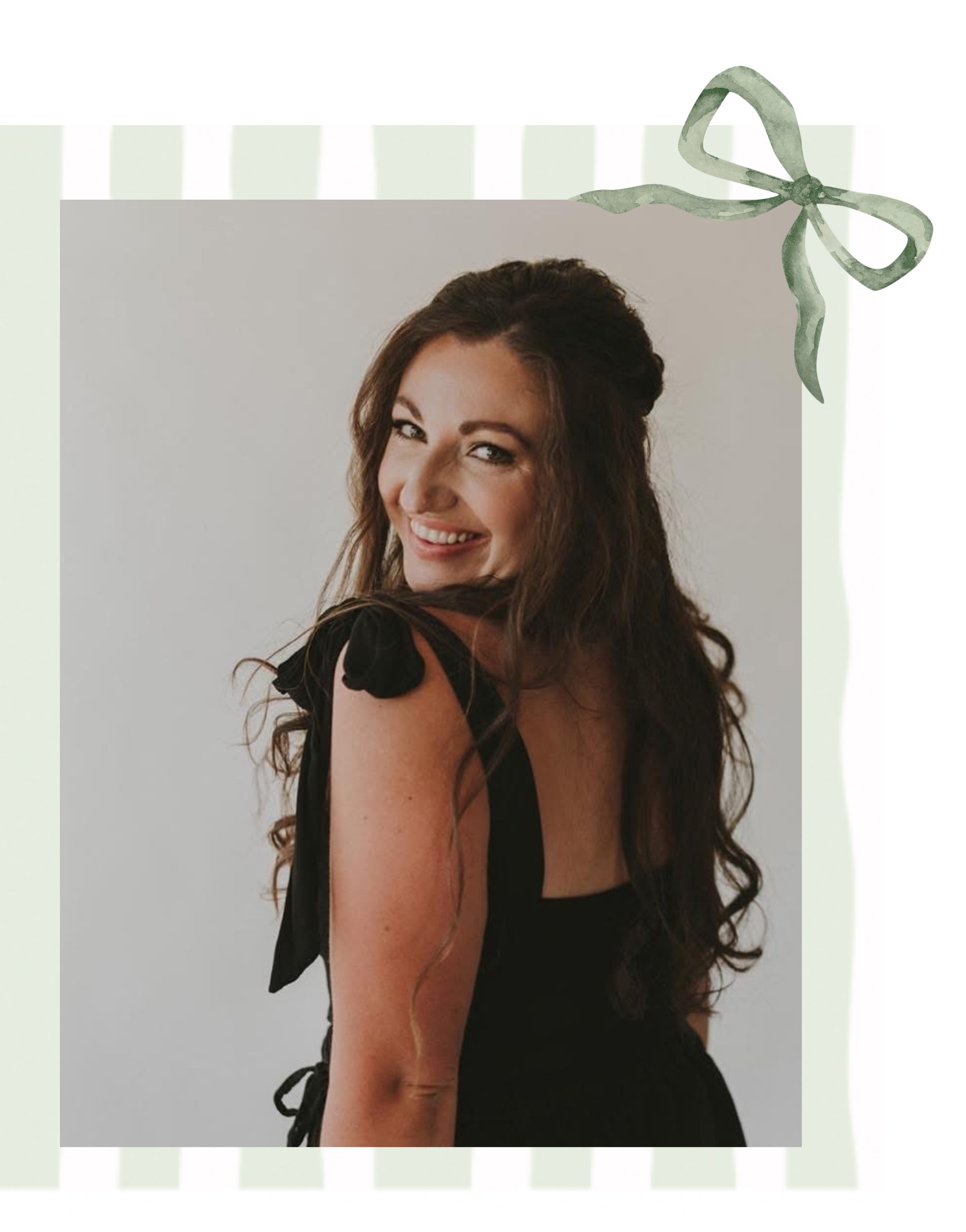 A woman with long wavy brown hair smiling and looking at the camera, wearing a black dress with tied shoulders, standing against a plain wall, framed with a light green decorative border and ribbon.