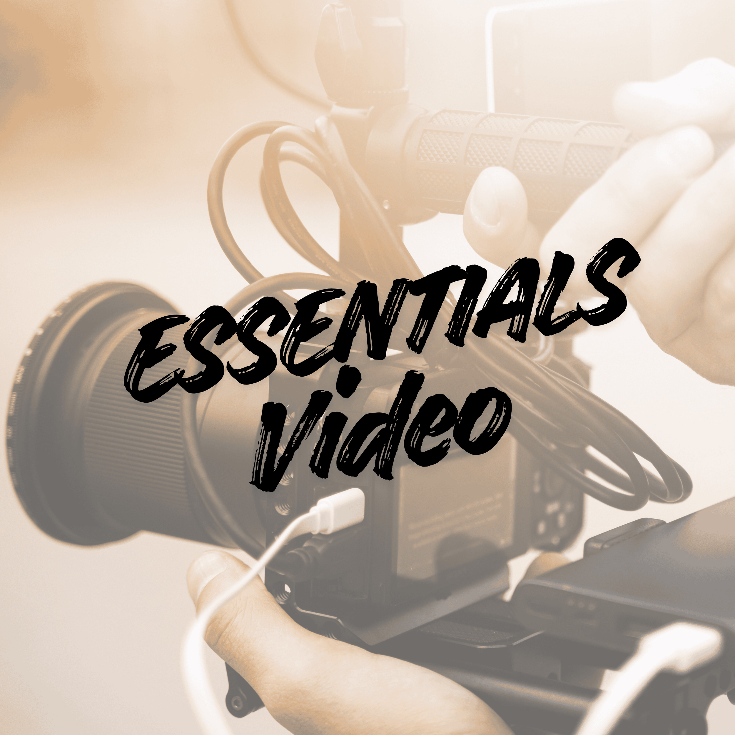 A professional video camera being operated by someone with their hand on the grip, with the words 'ESSENTIALS video' overlayed in bold black text.