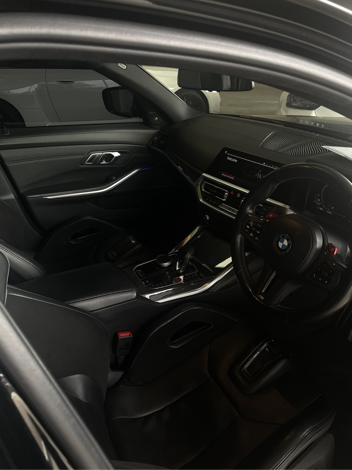 Interior of a BMW car with a black dashboard, steering wheel, center console, and digital display.