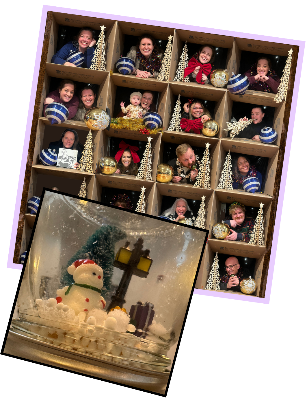 People posing inside a large cardboard box decorated for Christmas, with Christmas trees and ornaments, smiling for a group photo, and a separate snowman-themed snow globe in front.