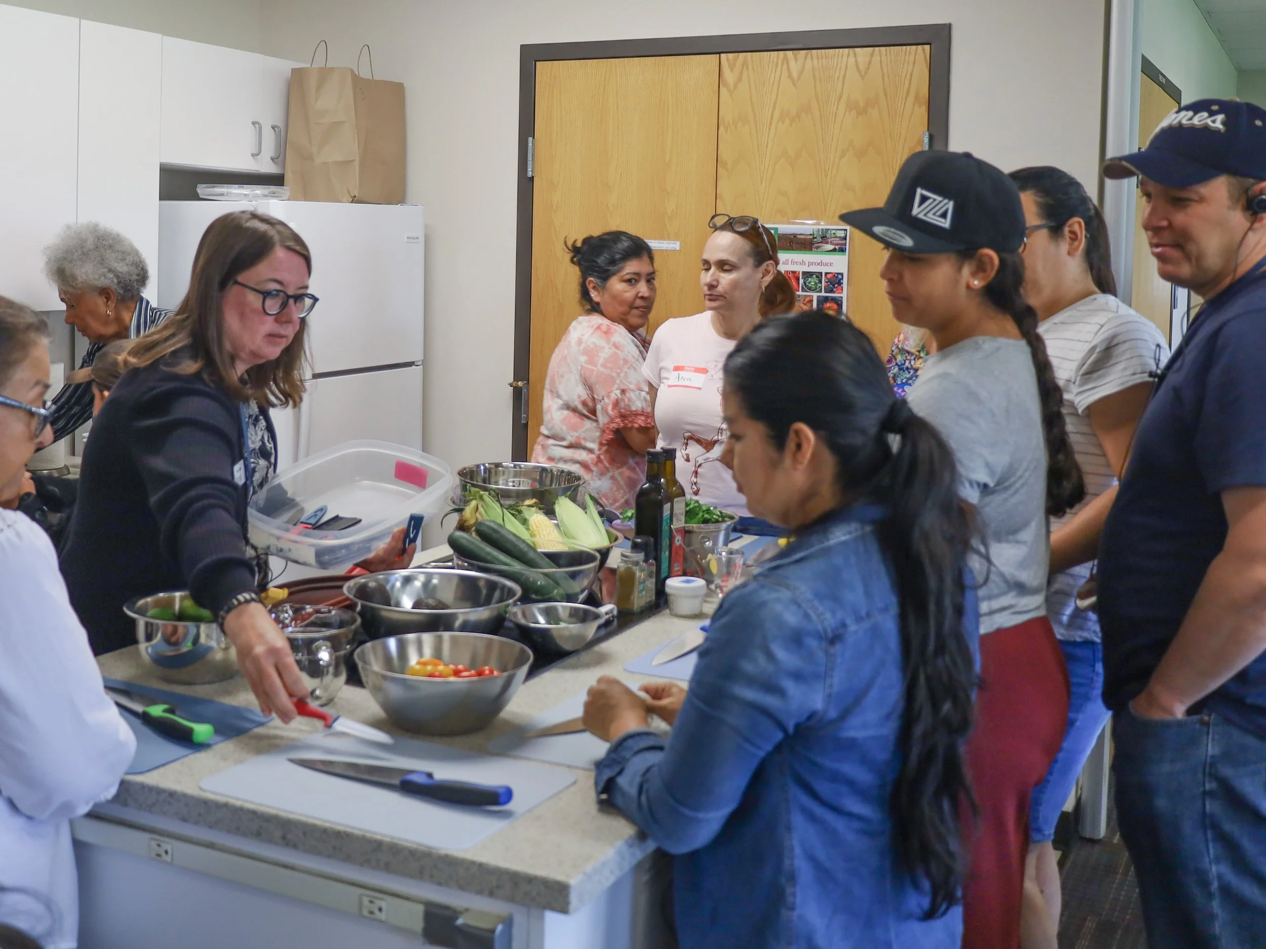 Class gathers around to watch instructor demo healthy recipes
