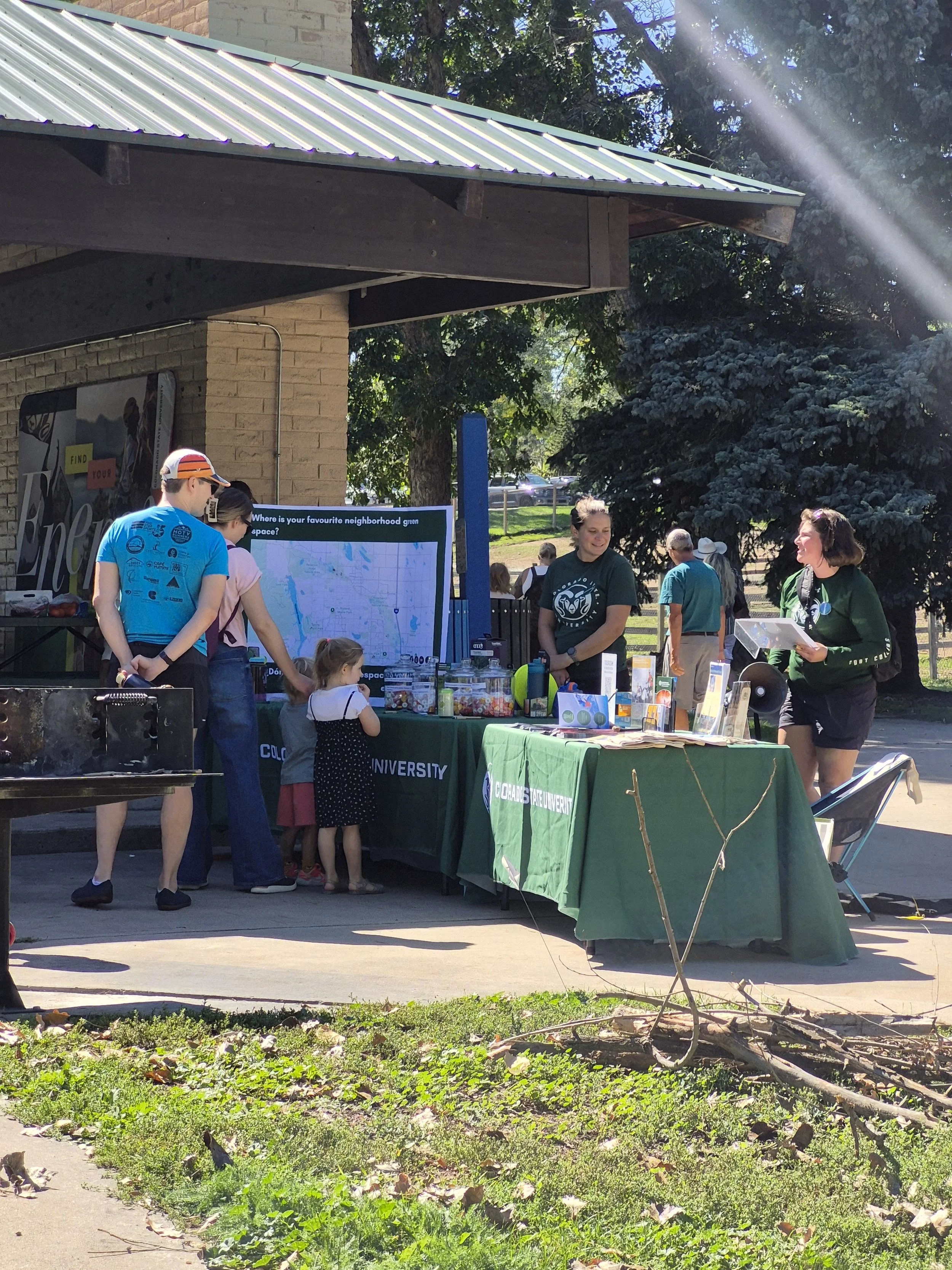 A family learns about natural areas at a Healthy by Nature Fair booth.