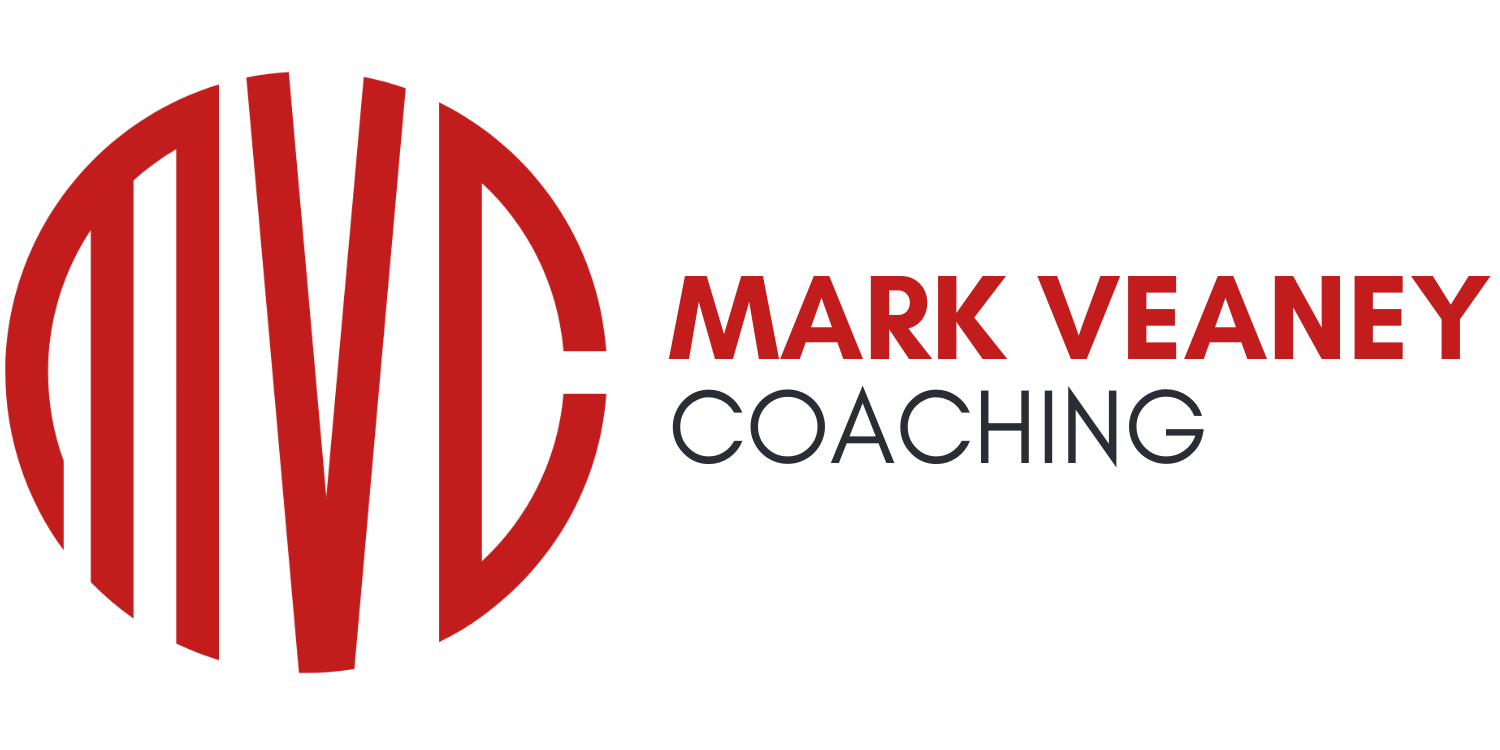 Logo for Mark Veaney Coaching with a round red emblem and black and red text.