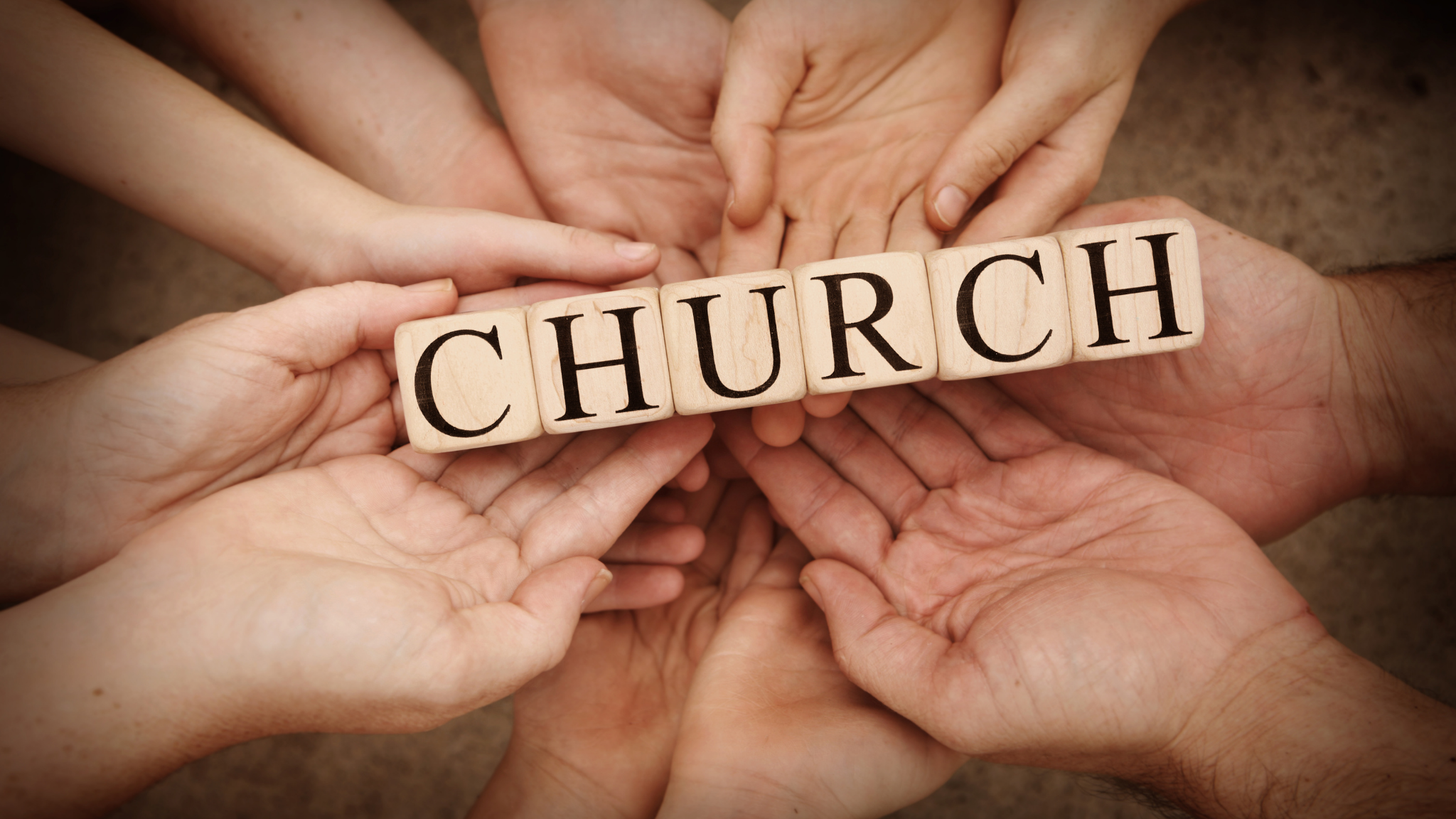 Multiple hands holding wooden blocks spelling out 'CHURCH'