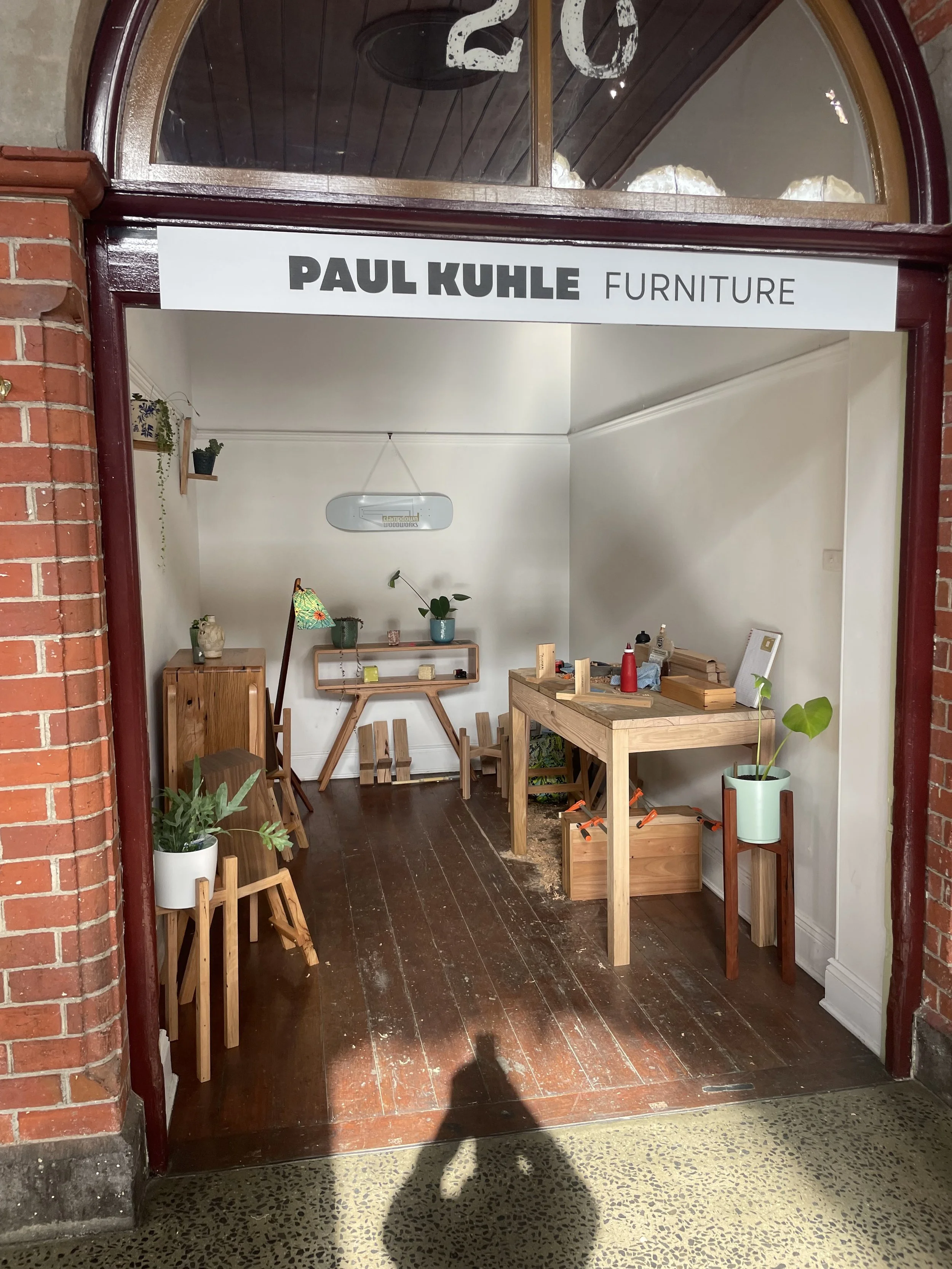 Interior display of wooden furniture and plants at Paul Kuhle Furniture store.