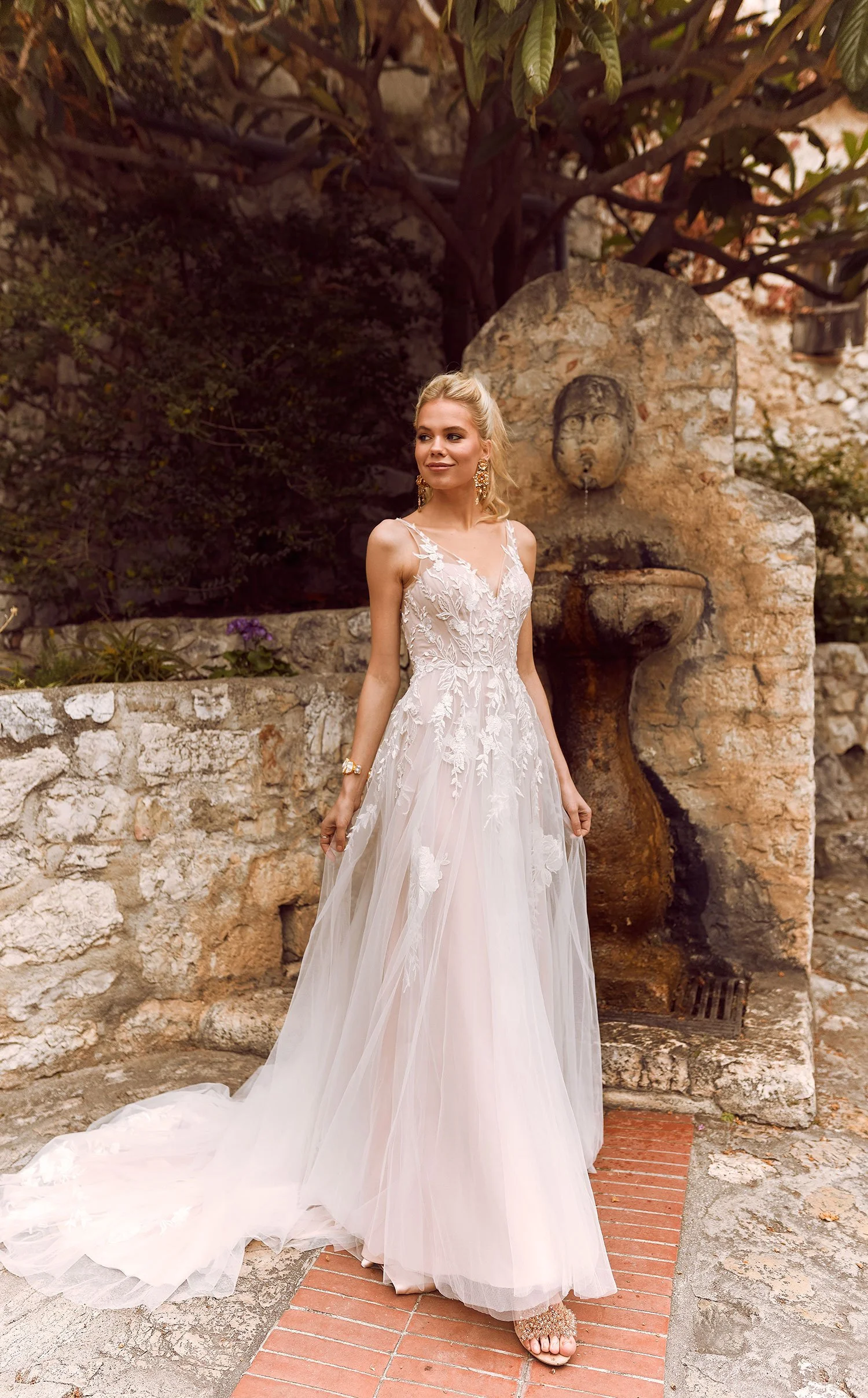 Madi Lane Halani A-line wedding gown with V-neck illusion straps, floral embroidered lace appliqué, and a scattering of sequin embellishments over soft layered tulle.