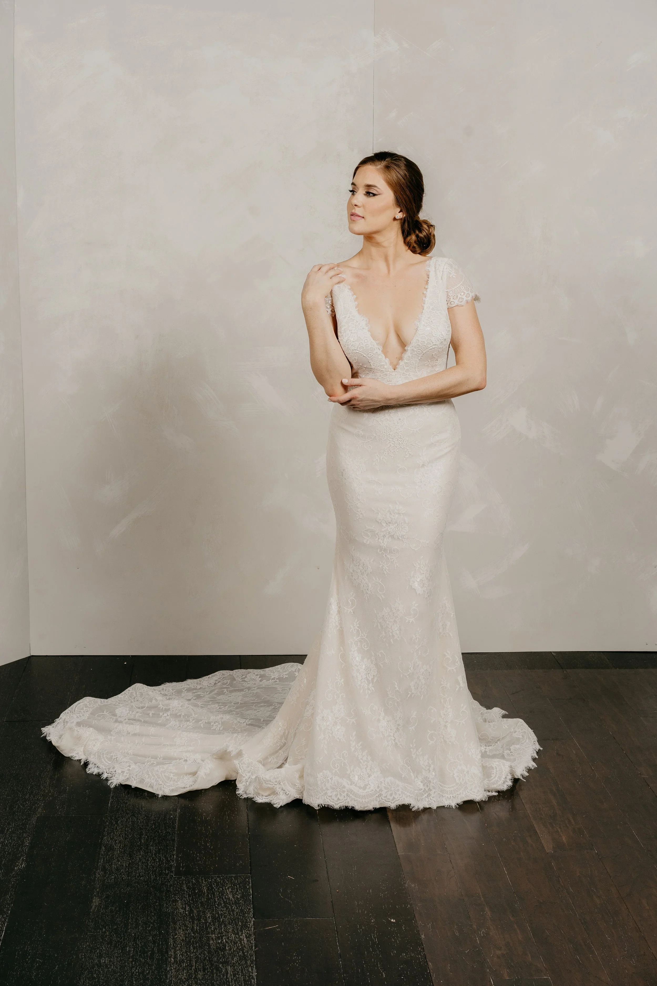 Elizabeth Lee Jules delicate fitted French lace wedding dress with cap sleeves and plunging neckline.