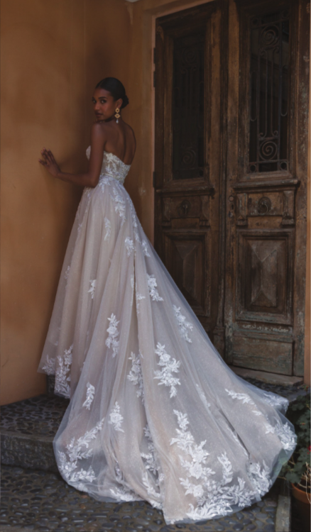 Madi Lane Pandora ballgown wedding dress with a strapless illusion bodice, motif lace adorned with sequins and beads, and a grand full-circle skirt and illusion train.