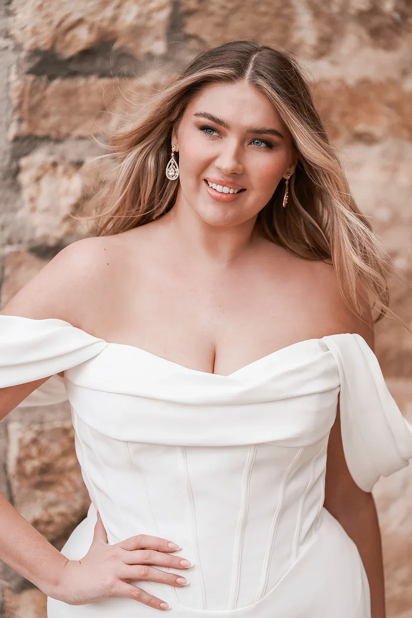 Allure Bridals W500 plus size fit and flare wedding gown with exposed boning bodice, soft cowl drape, and off-the-shoulder neckline and sleeve.