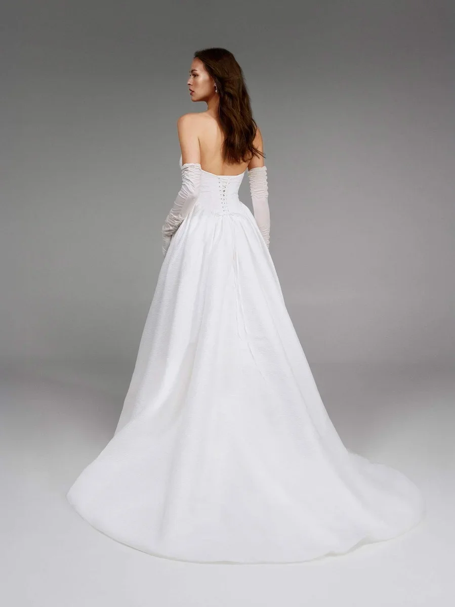 Pronovias Alby strapless jacquard ball gown wedding dress with a corset bodice, lace-up back, V-waist detail, and voluminous puffed skirt.