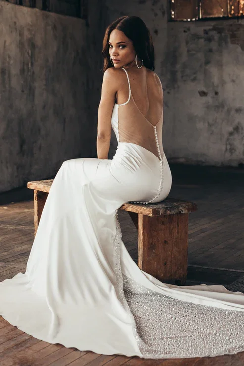 Serene Ame Ruby satin sheath wedding dress with cowl neckline, exposed bustier, beaded straps, and illusion back with beaded train.
