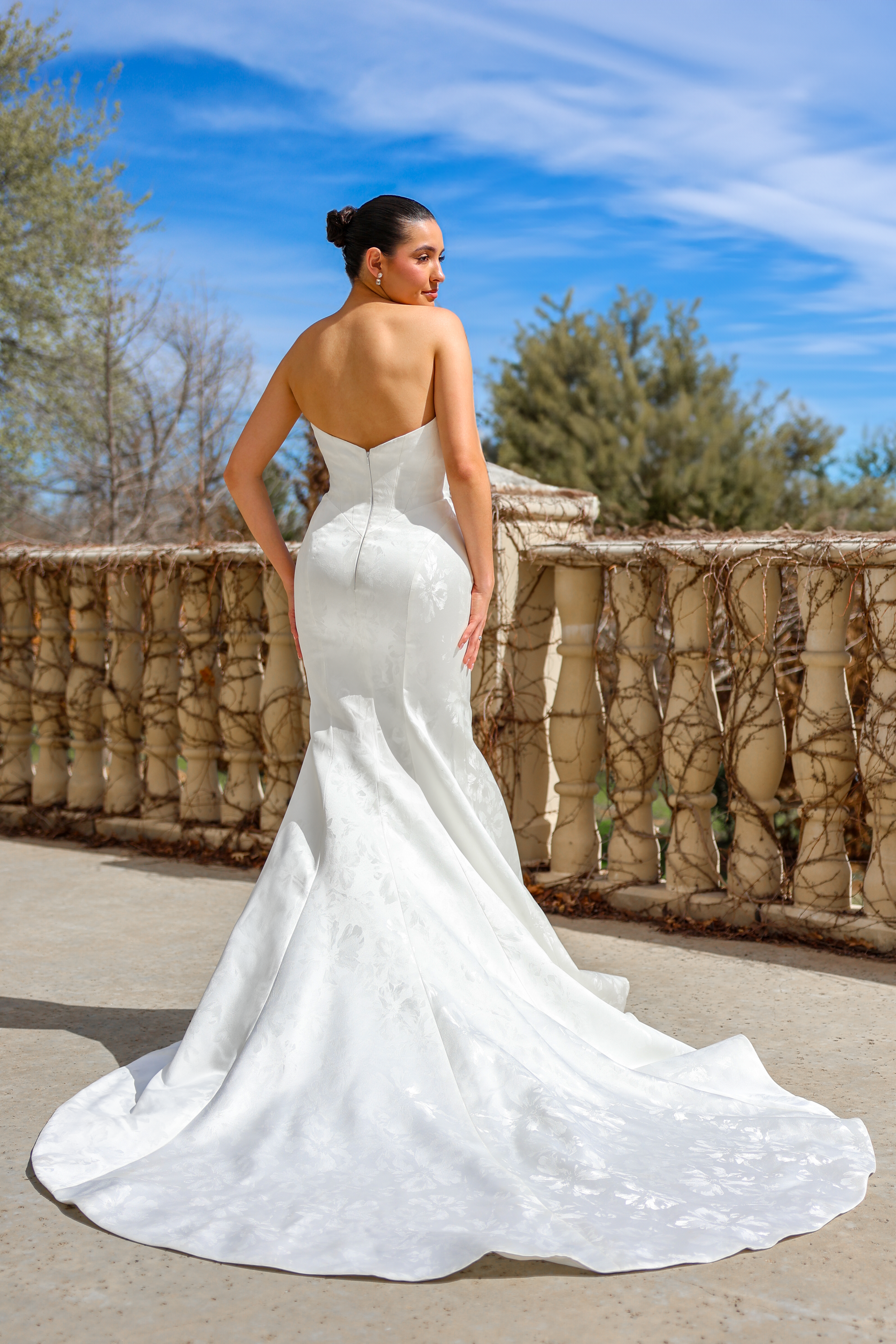 Elizabeth Lee Hunter sleek floral jacquard mermaid wedding dress with strapless straight neckline and dramatic sweep train.