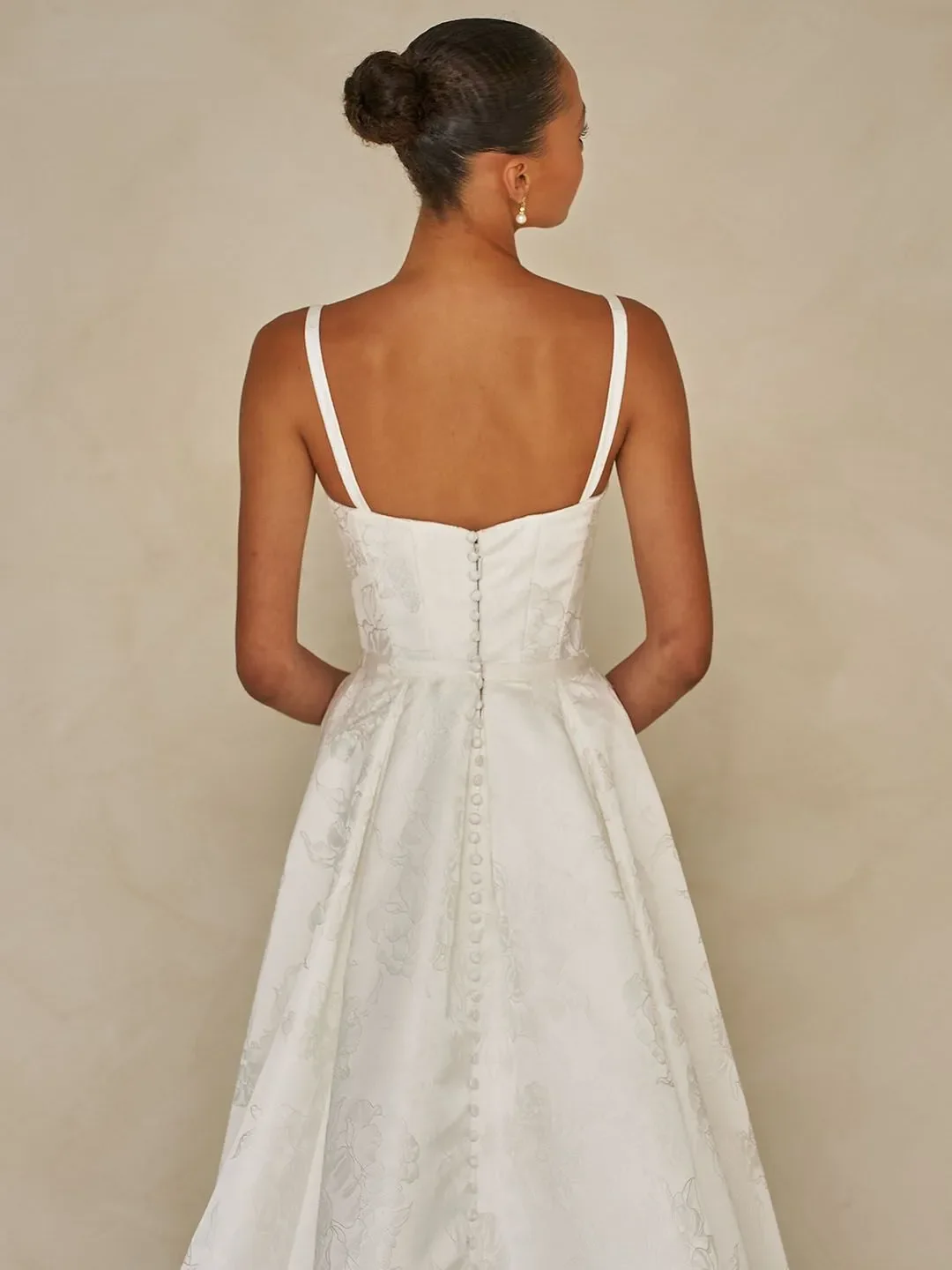 Madi Lane Walsh floral jacquard sheath wedding gown with a square neckline, detachable straps, and an included A-line overskirt for two distinct looks.