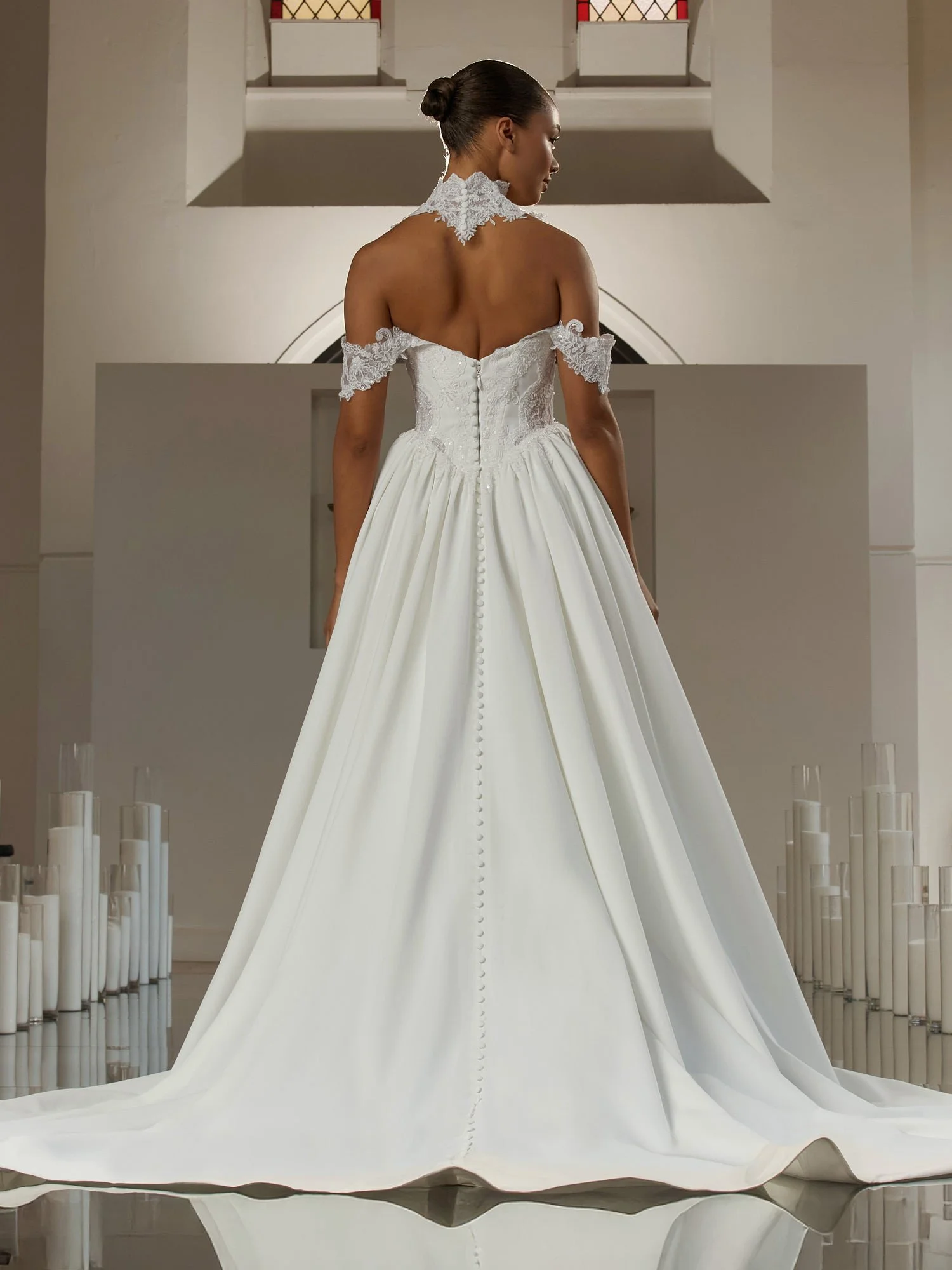 The strapless, sweetheart neckline is trimmed by scalloped lace, softening the shape of the bodice.